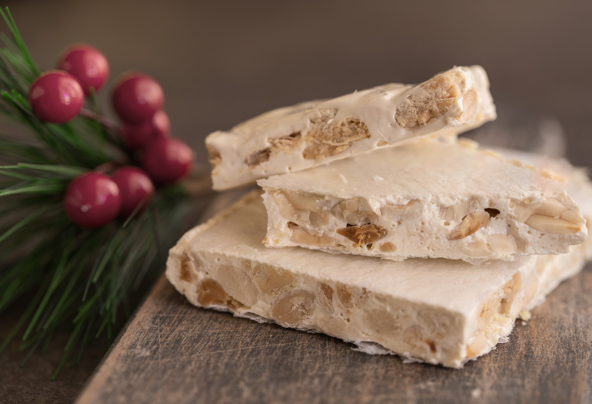 Turron, typical Christmas sweet in Spain. Almond nougat on dark wooden background with Christmas decoration; Shutterstock ID 1570848361; Purpose: Virtual Christmas Guides; Brand (KAYAK, Momondo, Any): Kayak; Client/Licensee: KAYAK