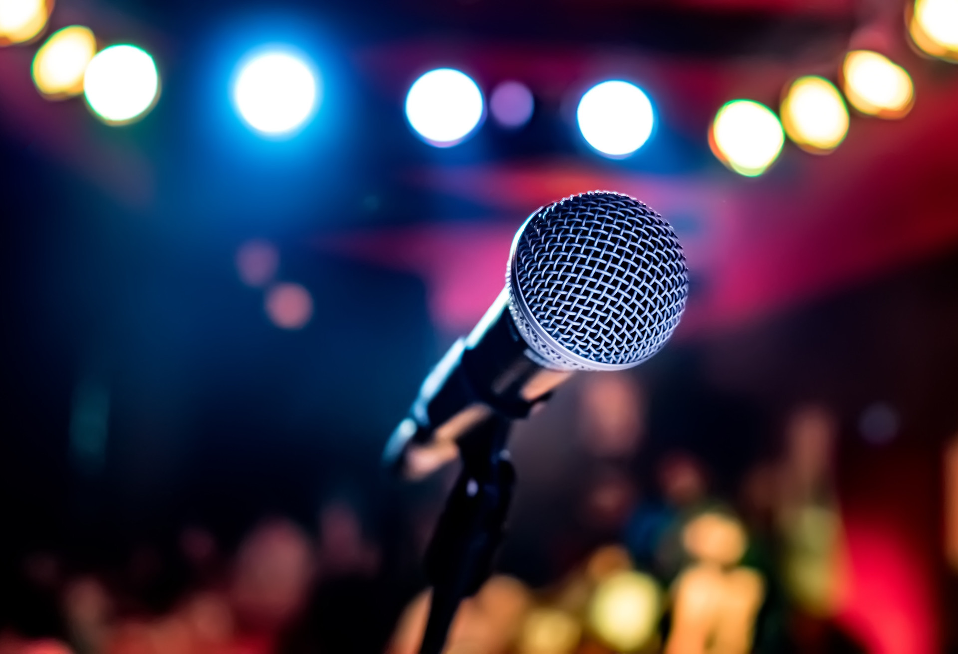 Public performance on stage Microphone on stage against a background of auditorium. Shallow depth of field. Public performance on stage.; Shutterstock ID 1017257791; Purpose: Commercial emails; Brand (KAYAK, Momondo, Any): All; Client/Licensee: Carlee Shults