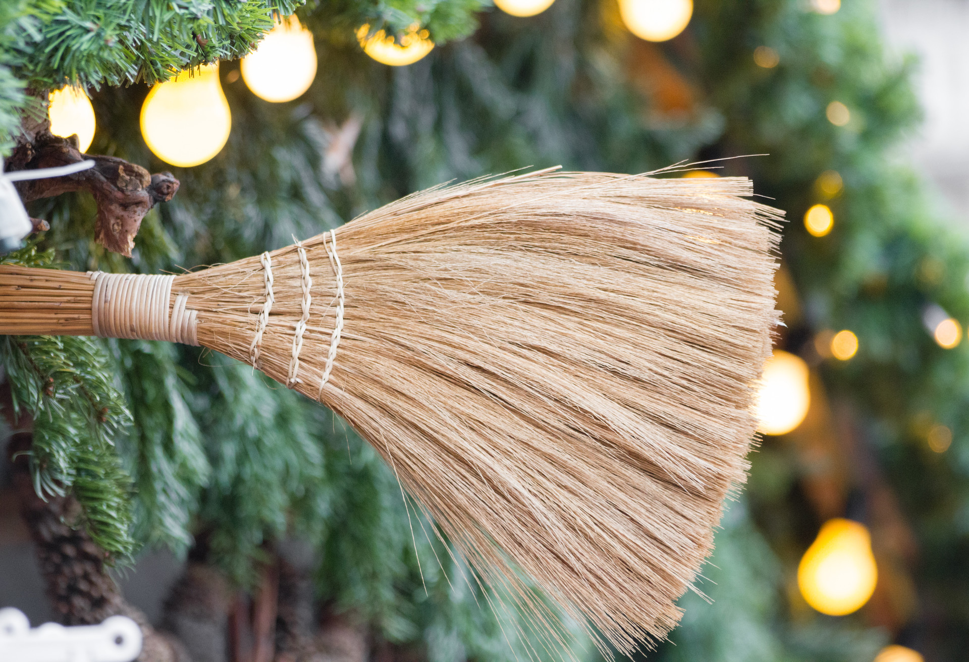Broom close-up with pine branches and light bulbs