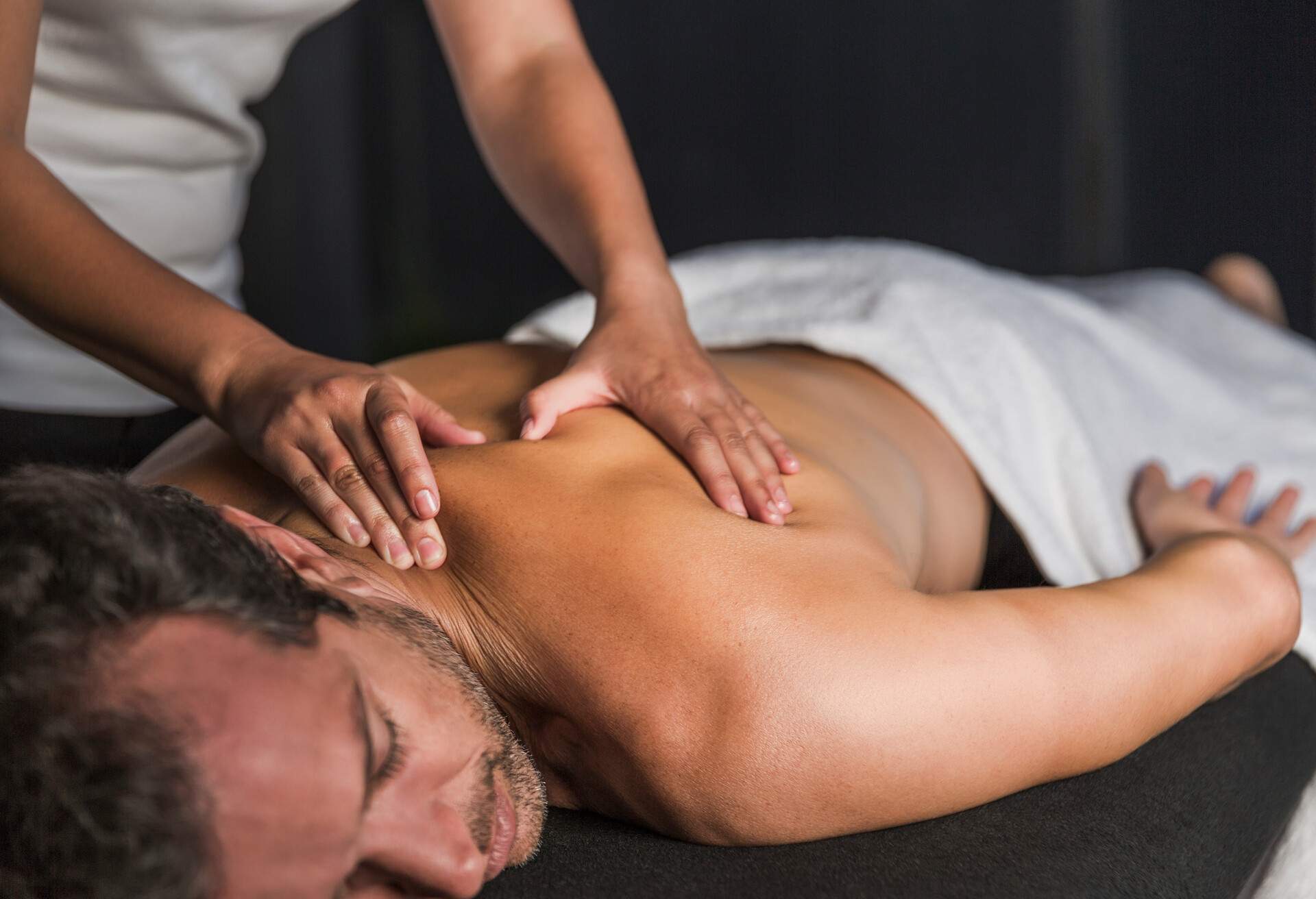  A man lies in a spa bed and receives a back massage.
