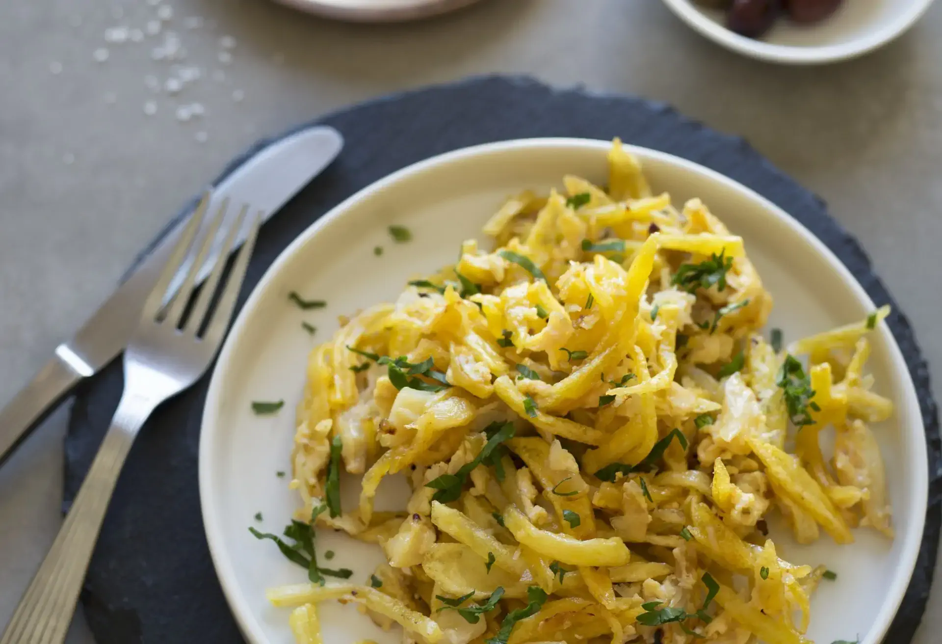 Bacalhau à Brás on a white plate with knife and fork