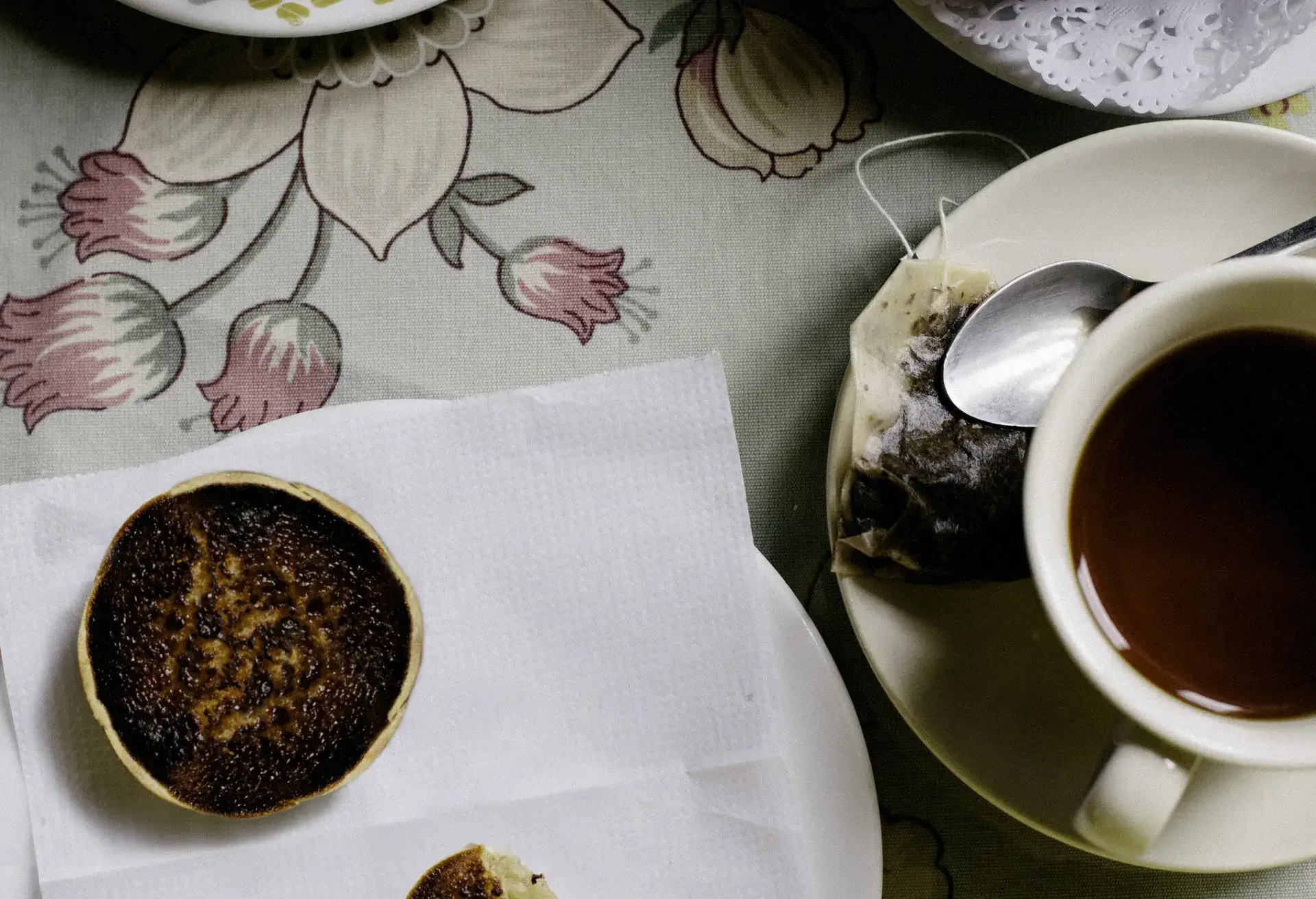 Queijadas de Sintra on a white paper with tea cup next to it