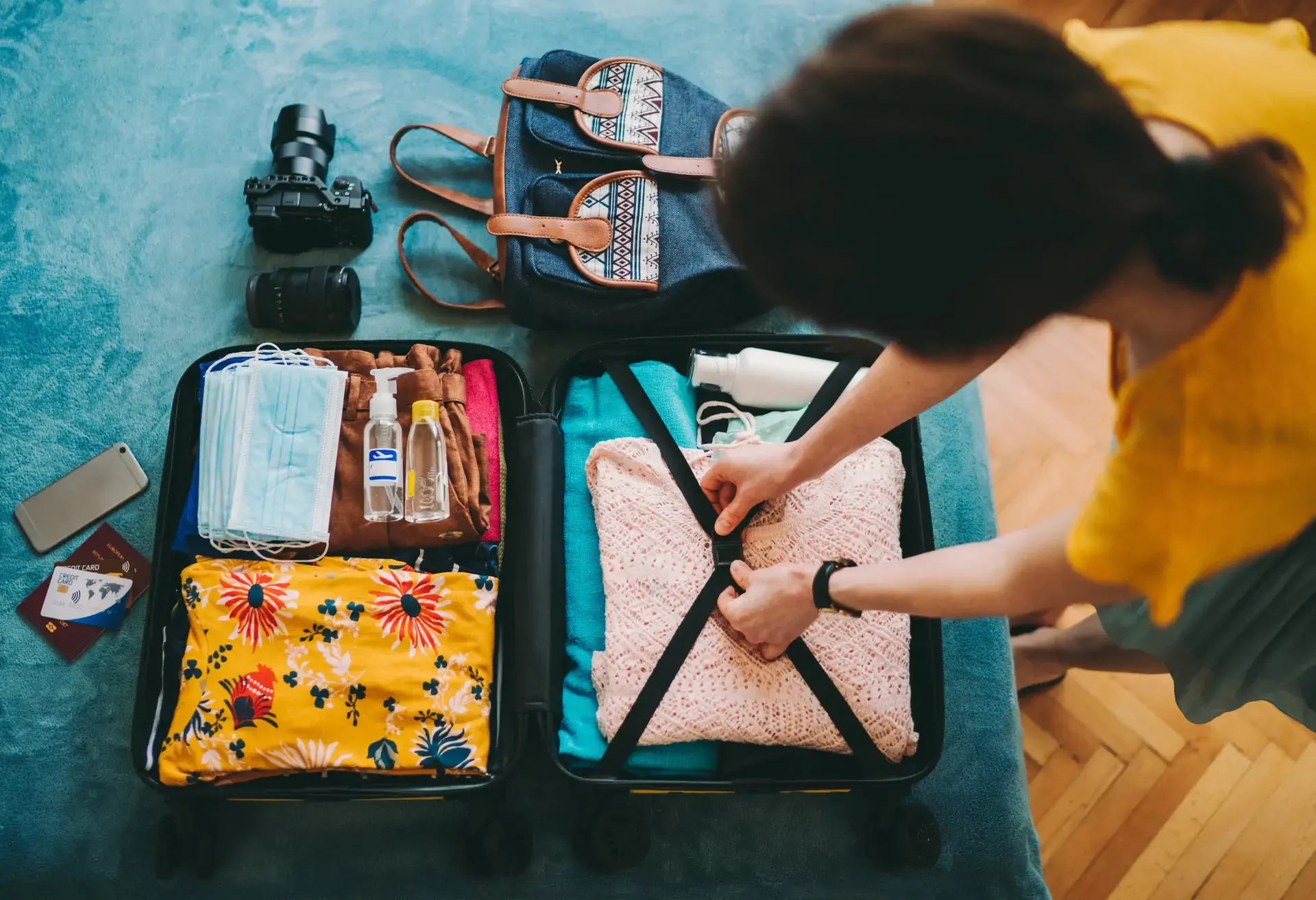 A woman packing a carry on back and making sure all items are packed