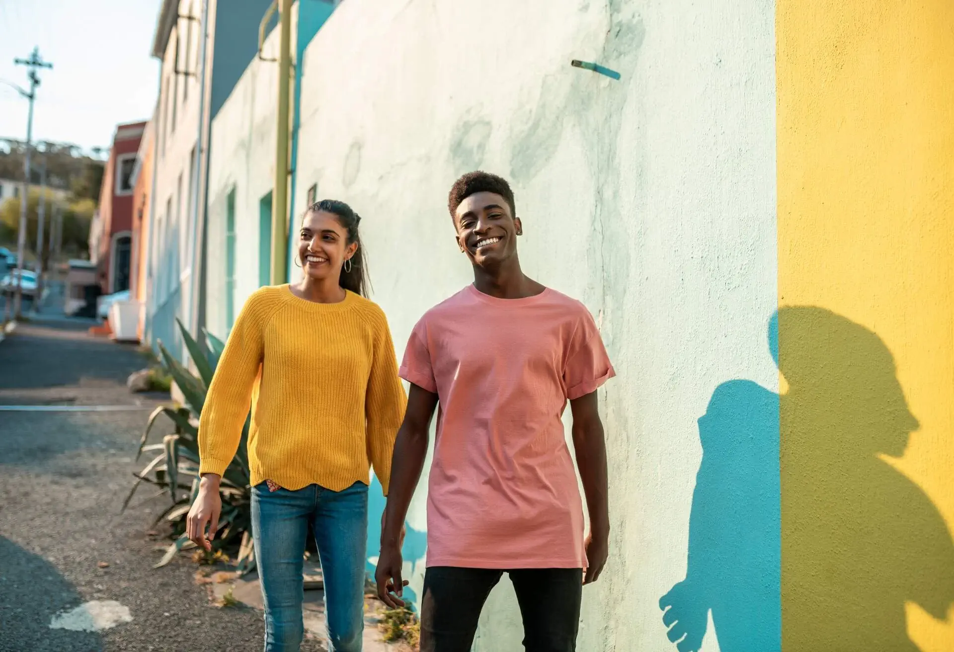A happy couple in colourful clothes walking down a street in Cape Town.