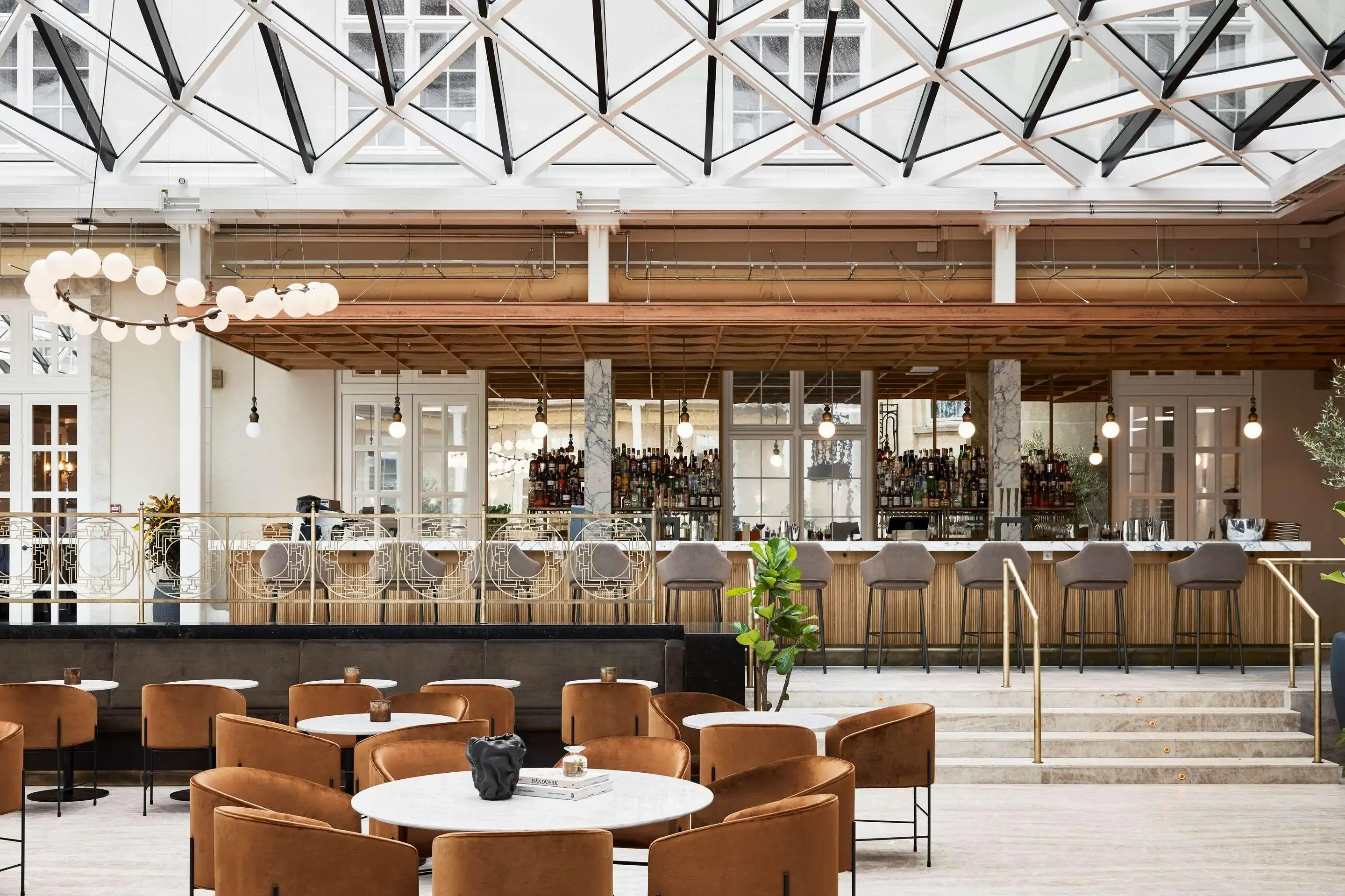 Villa Copenhagen bar and lounge with glass ceiling and stylish brown chairs