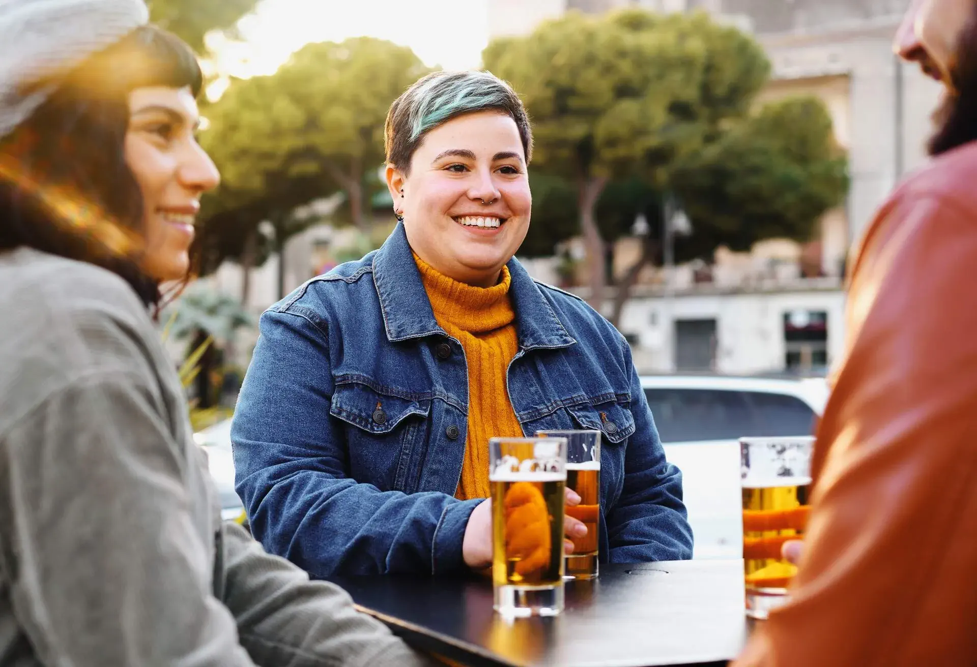 A circle of friends telling stories and drinking beer outdoors.