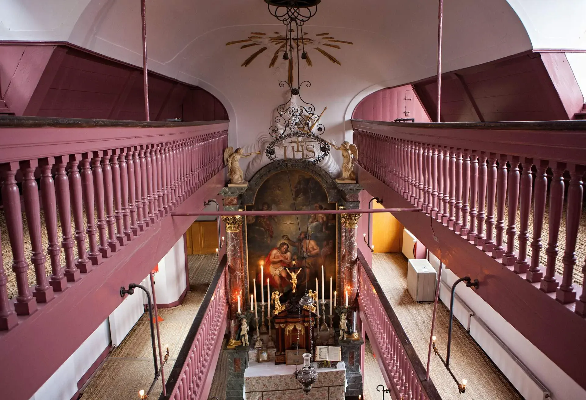 The small church 'Ons Lieve Heer Op Solder' with it's alter in the middle and pink railing 