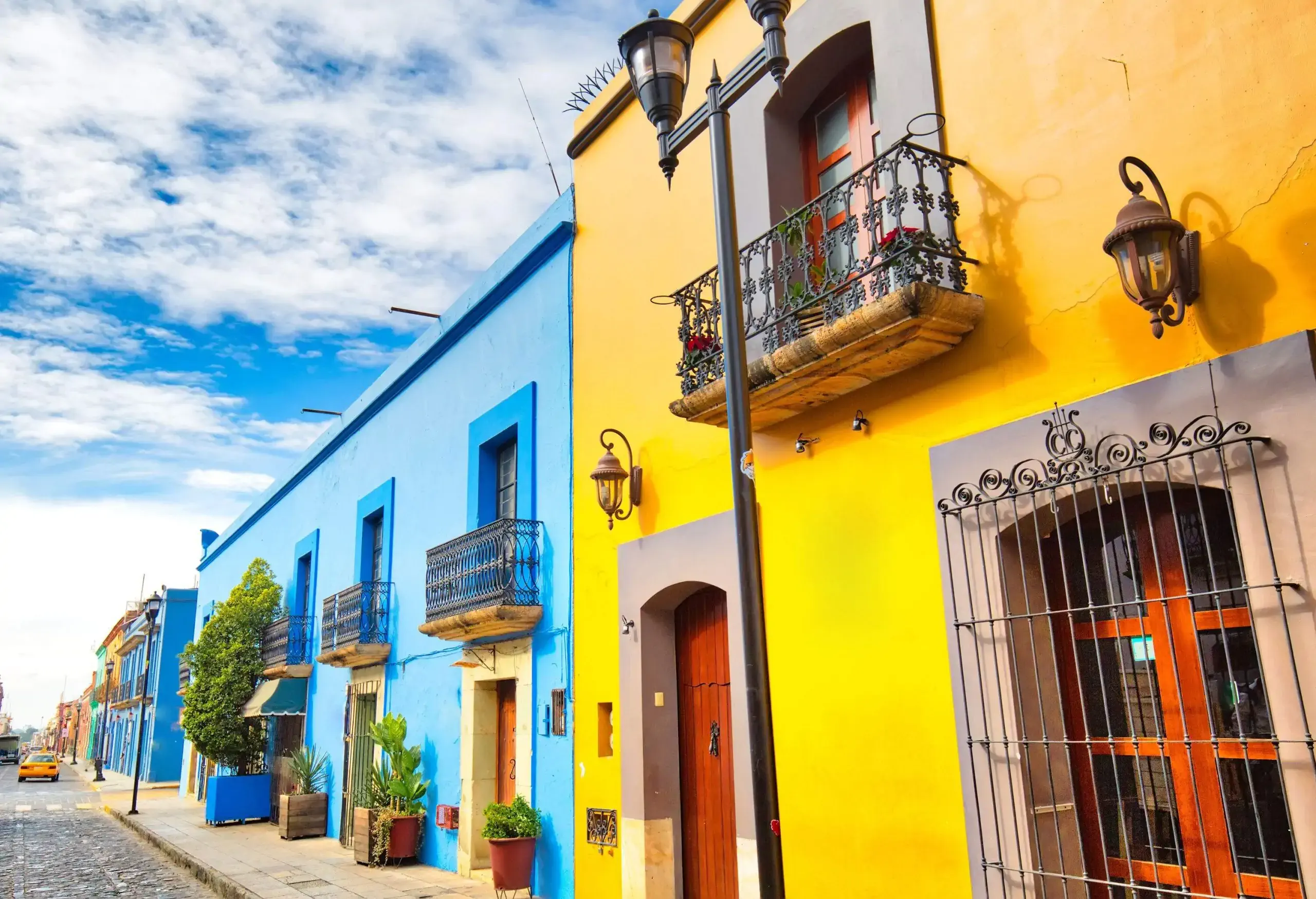 The street is lined with colourful buildings that stretch from wall to wall, featuring charming balconies.