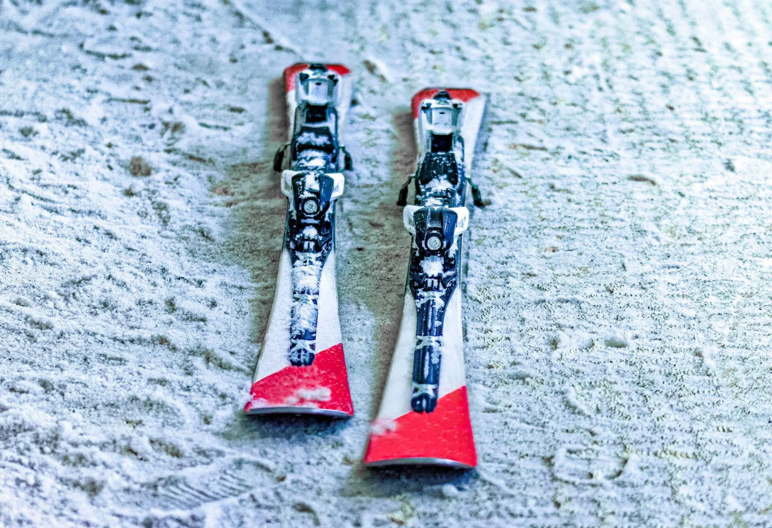 A pair of red skis lying in snow