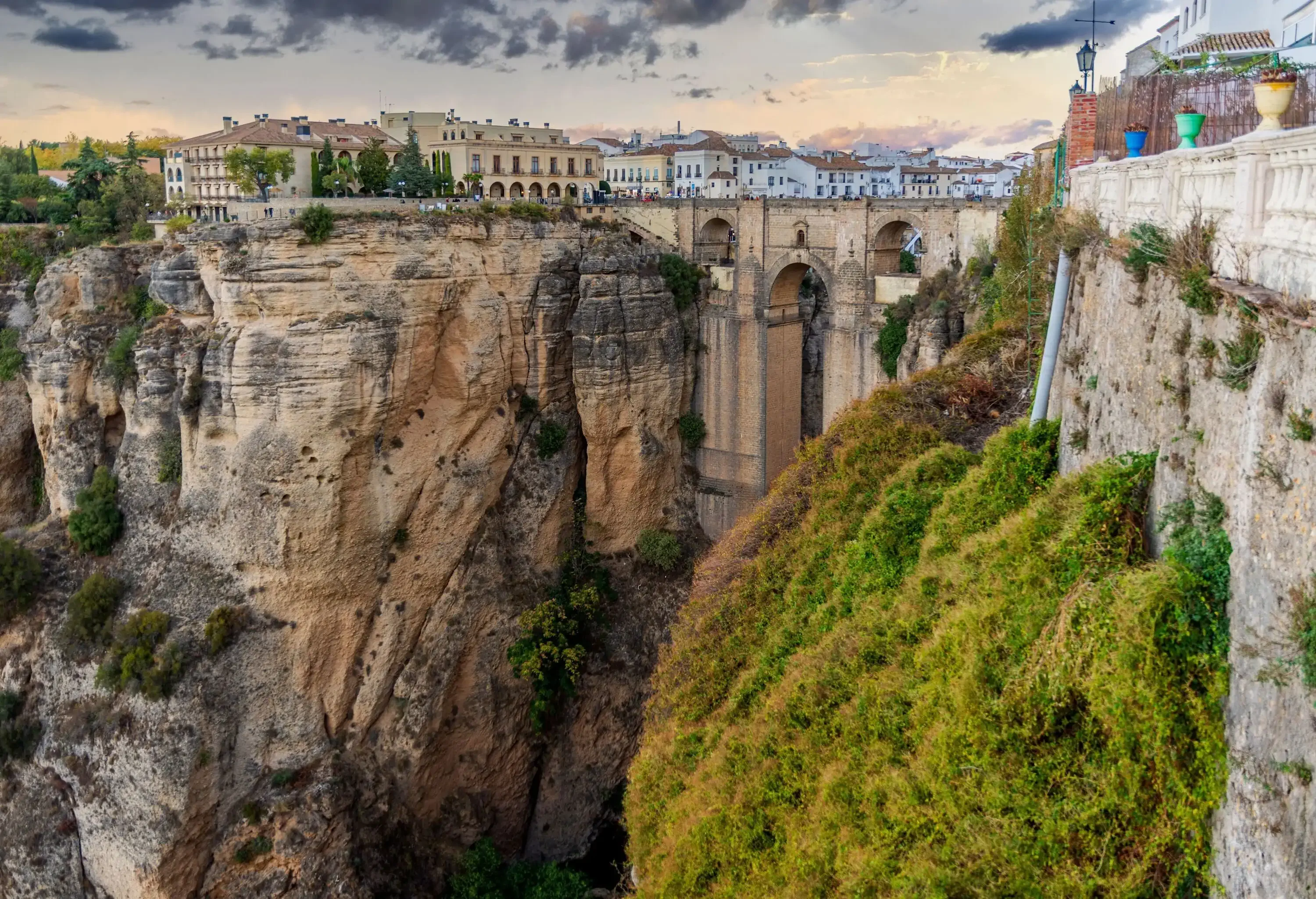 Buildings located on top of a deep gorge connected by an arch bridge.