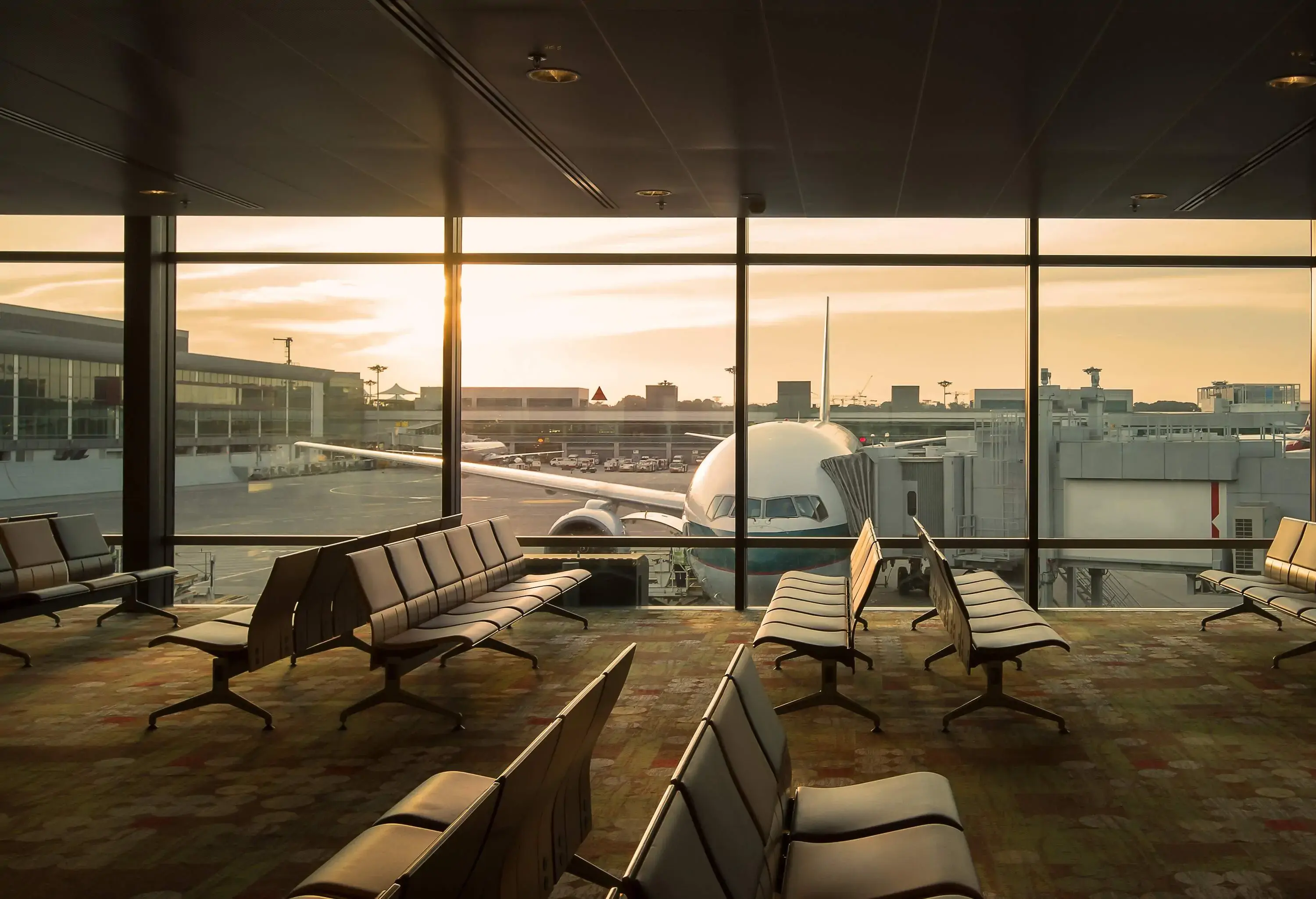 Empty airport seating area with an airplane outside the windows