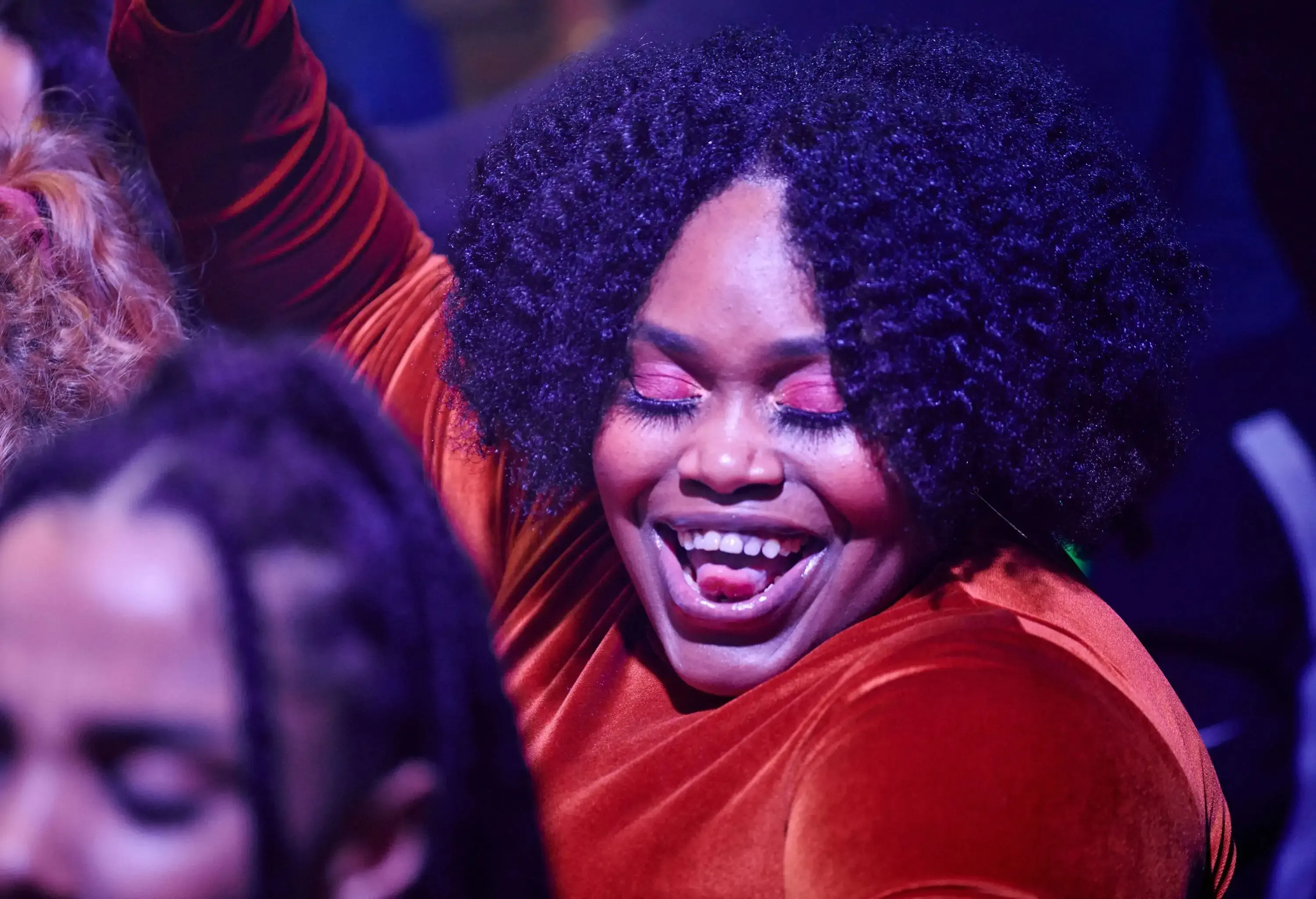 A happy, black kinky woman enjoying the night dancing at the bar.