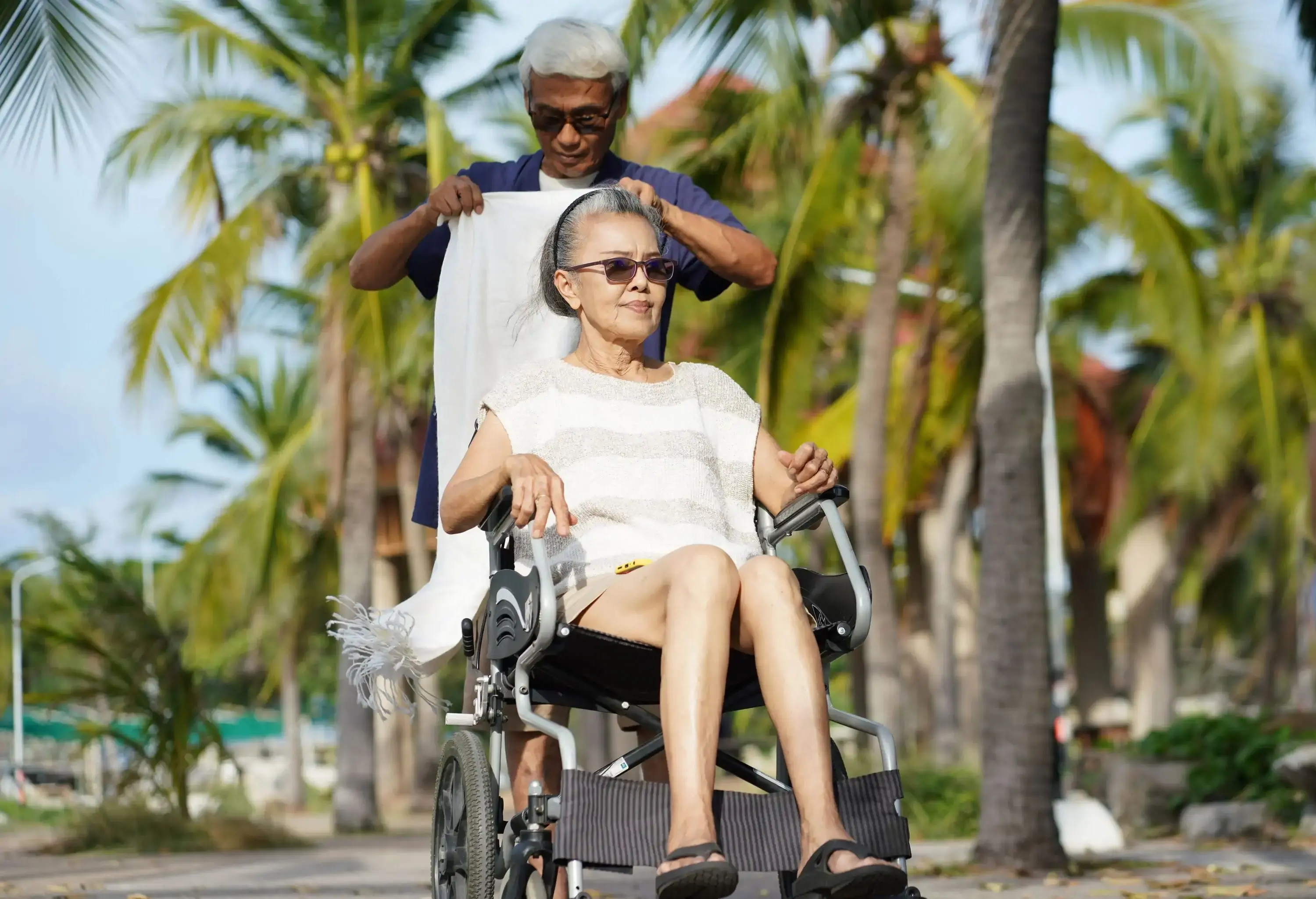 Senior Couple with wheelchair at tropical resort