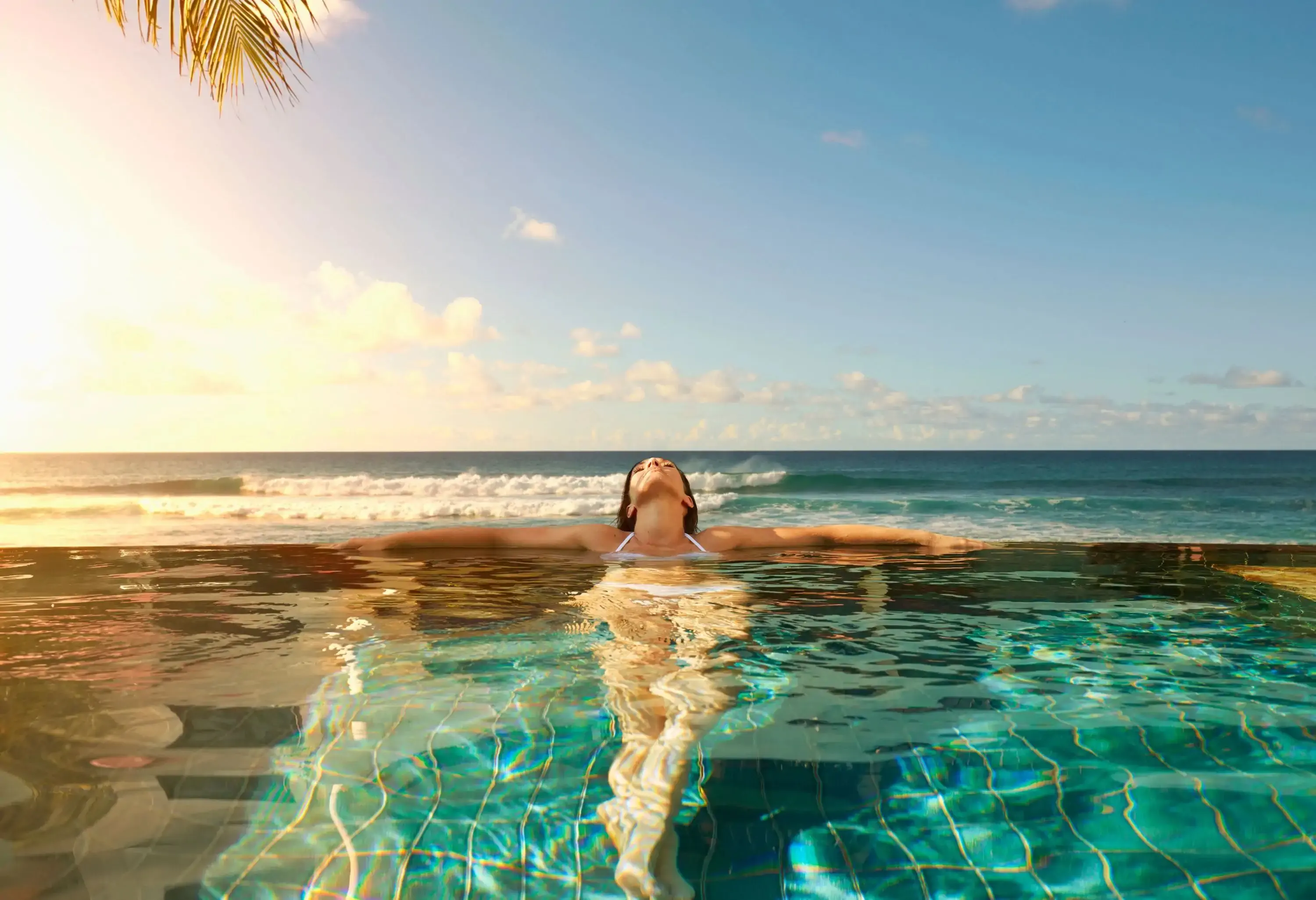 Woman lying in a swimming pool of a beach resort