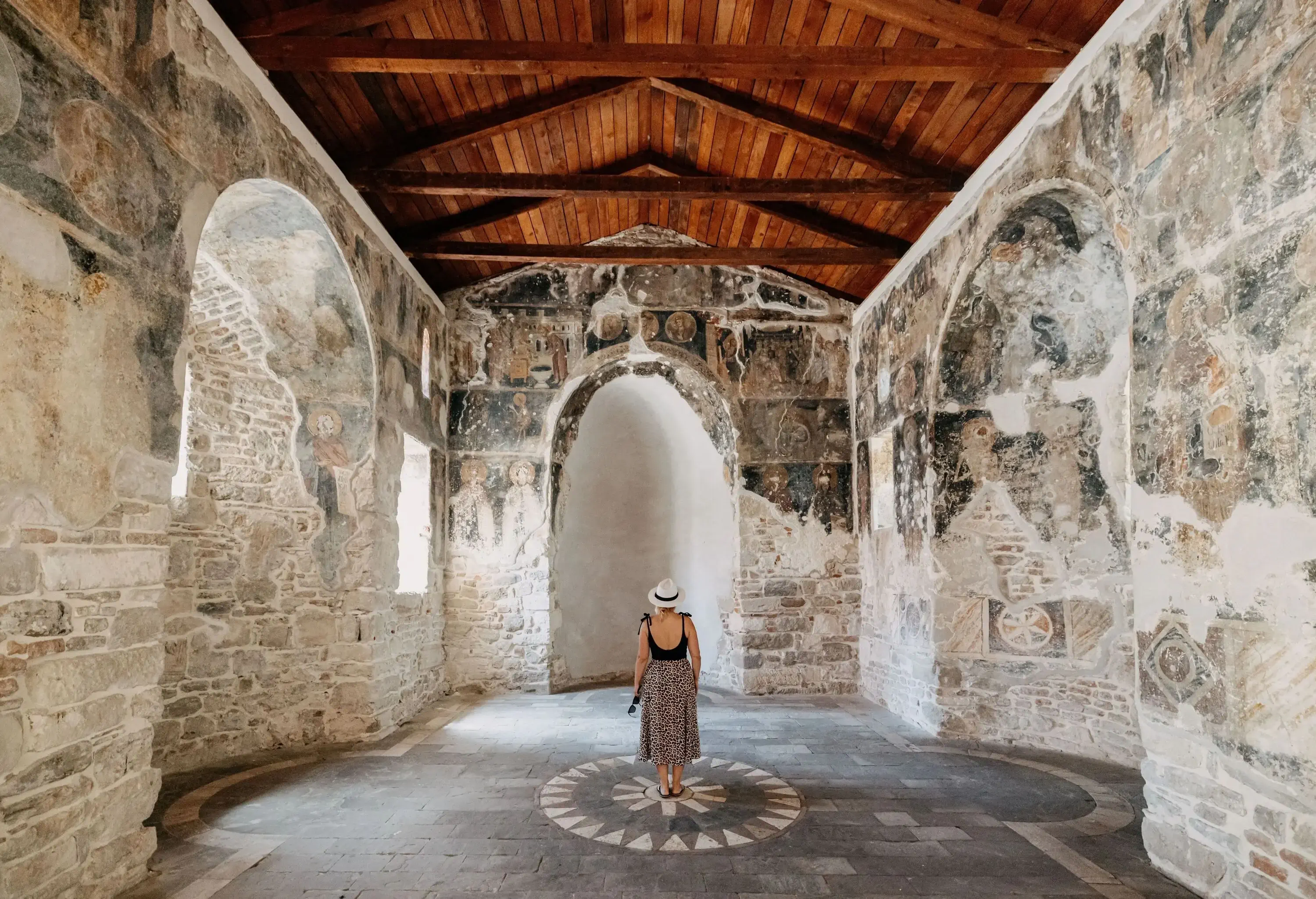Rear view of tourist exploring ancient Monastery during summer vacation