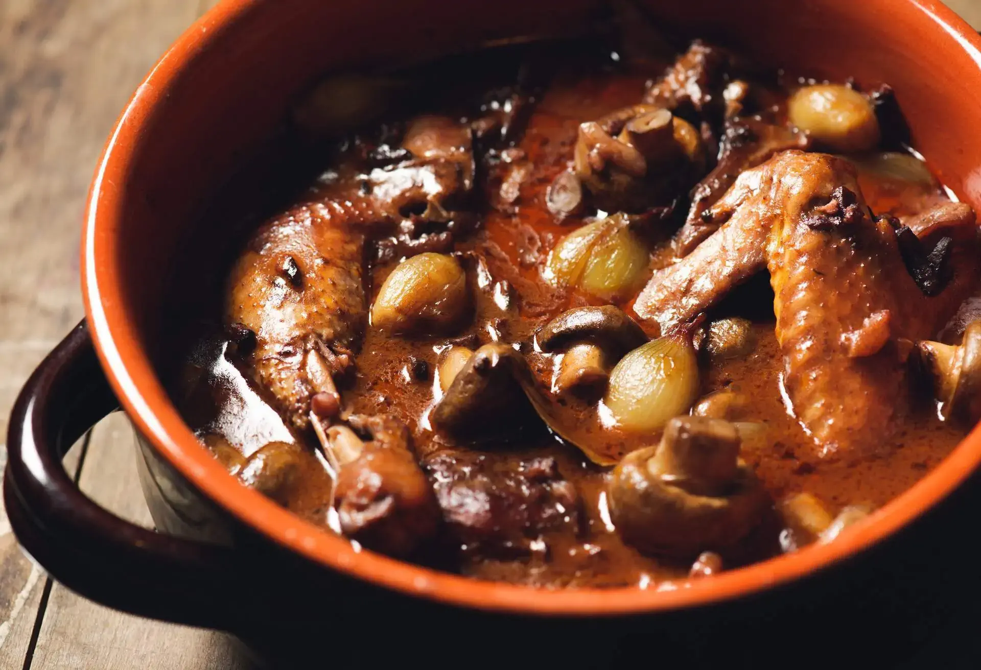 Black and brown ceramic pot with Coq au Vin