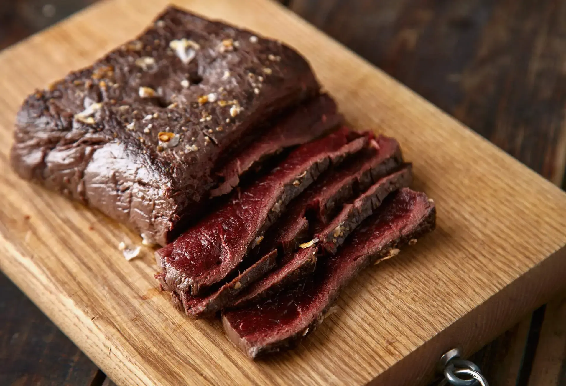 Closeup of sliced medium rare cooked whale meat stake wooden table 