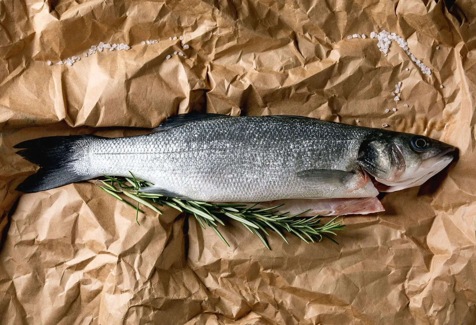 fresh fish with a rosemary on brown paper