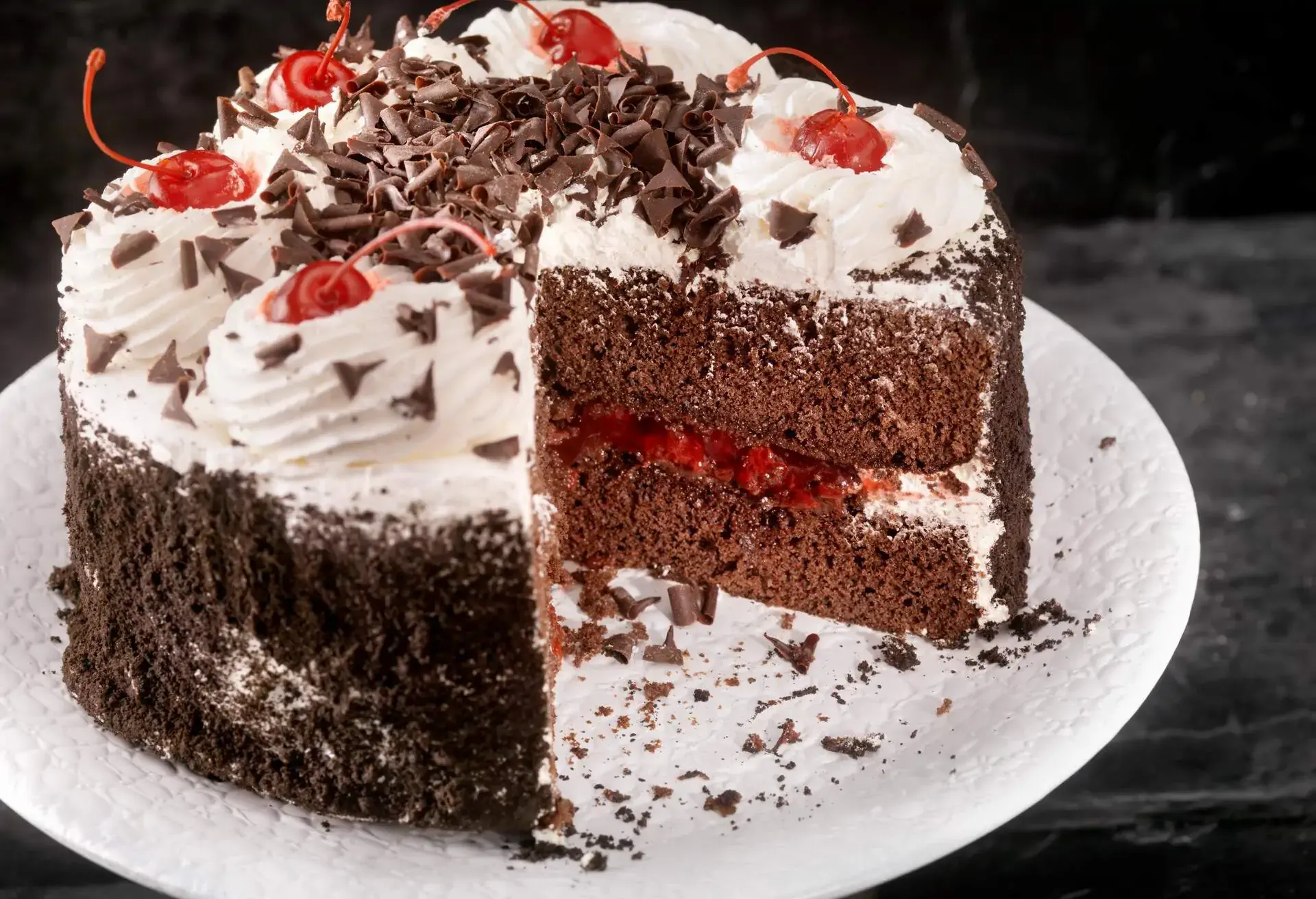 White plate with Schwarzwälder Kirschtorte with one big slice missing