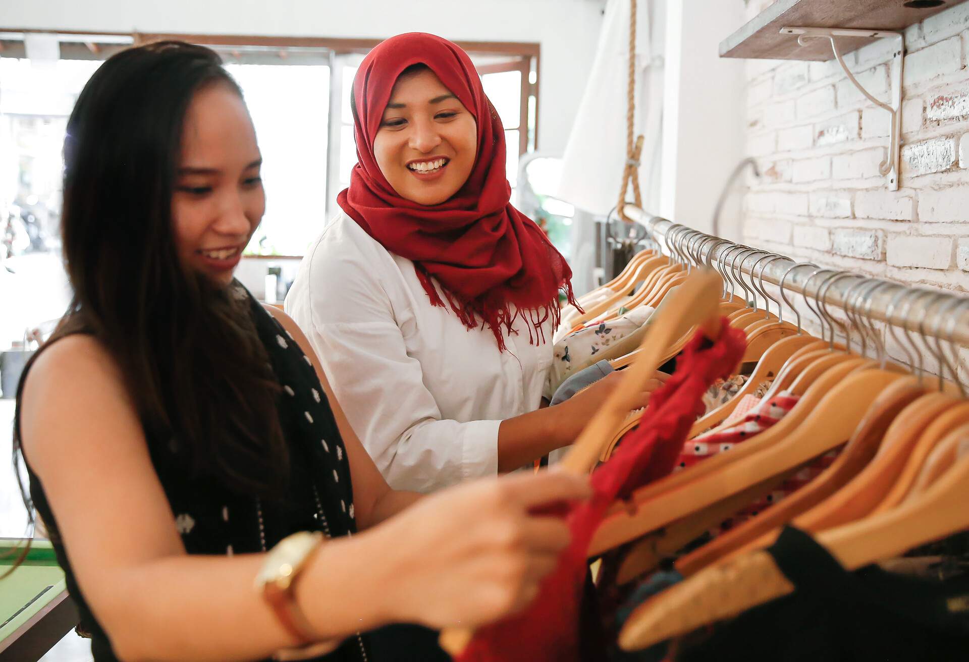 Close up two females Asian friends going shopping together in a women's boutique