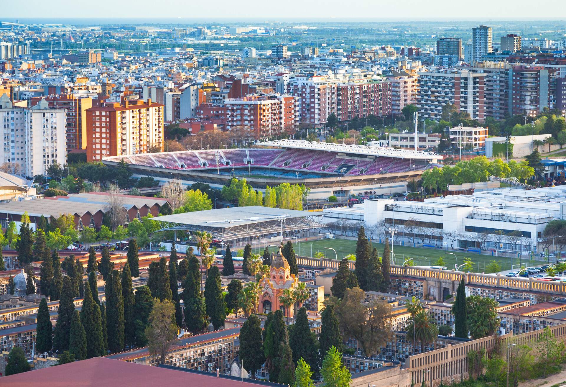 A landscape of a flourishing city featuring a massive sports stadium and towering buildings.