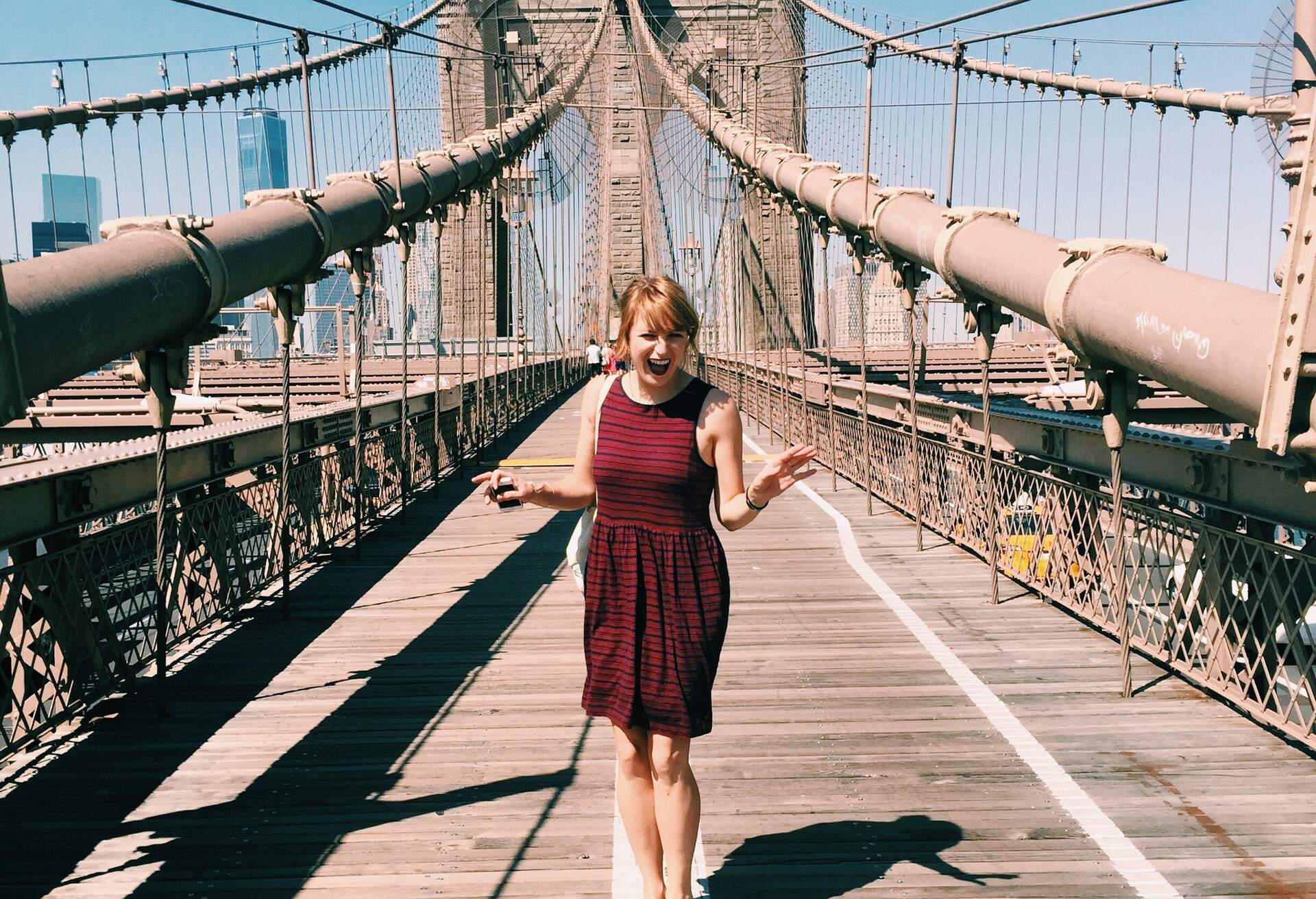 A person strikes a pose near the pedestrian walkway of a captivating cable-stayed bridge.