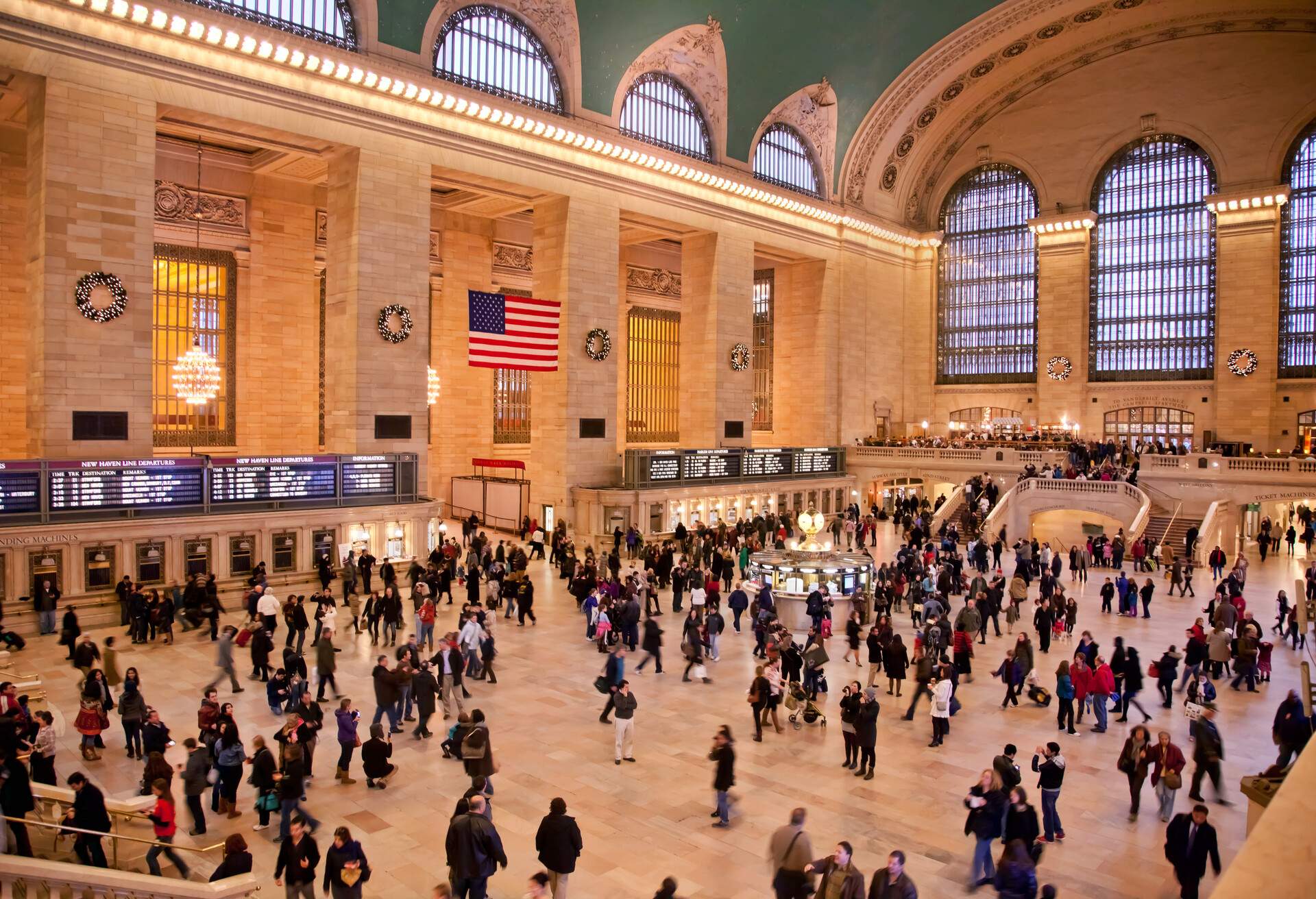 A busy Grand Central Terminal Main Concourse with many passengers booking a train ride.
