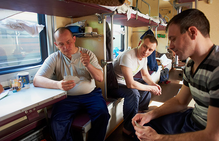 Lokale passagerer spiller kort i toget på Den Transsibiriske Jernbane