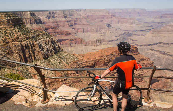 A road cyclist pauses to look at the view on the south rim, Grand Canyon National Park.