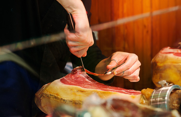 Jamón being cut in thin slices ready to eat by a Caucasian man Valencia Spain