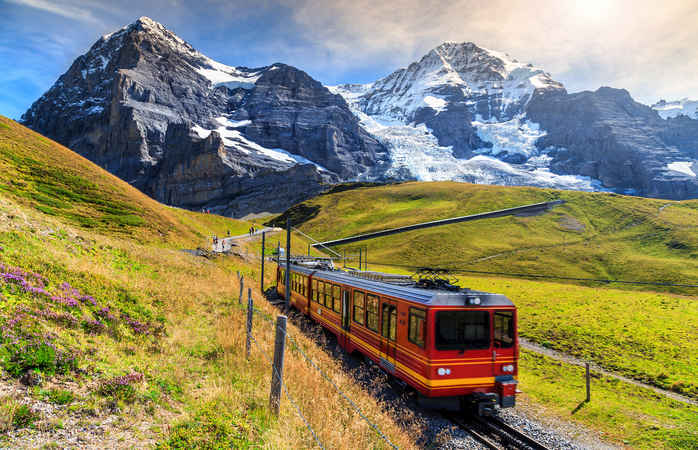 Famous electric red tourist train coming down from the Jungfraujoch station(top of Europe) in Kleine Scheidegg,Bernese Oberland,Switzerland,Europe