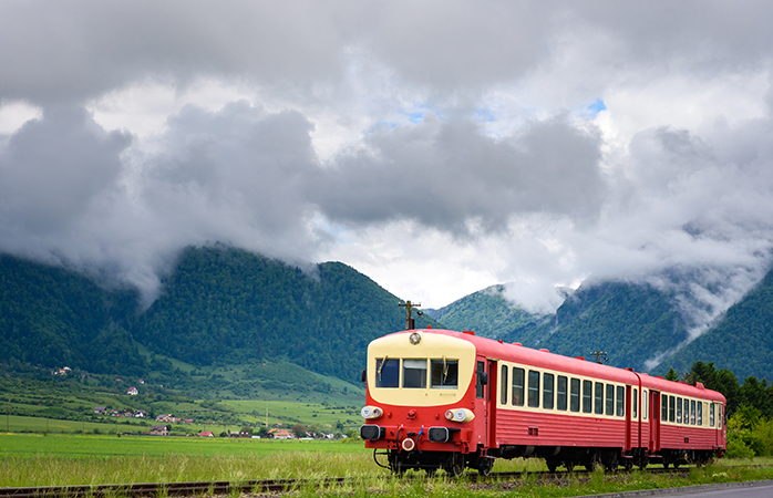 Train in Transylvania, Romania - Lovely train returning from the cloudy mountains in Piatra Craiului National Park near Bran and Zarnesti in Transylvania, Romania.; Shutterstock ID 739136488; Purpose: train routes article; Brand (KAYAK, Momondo, Any): momondo