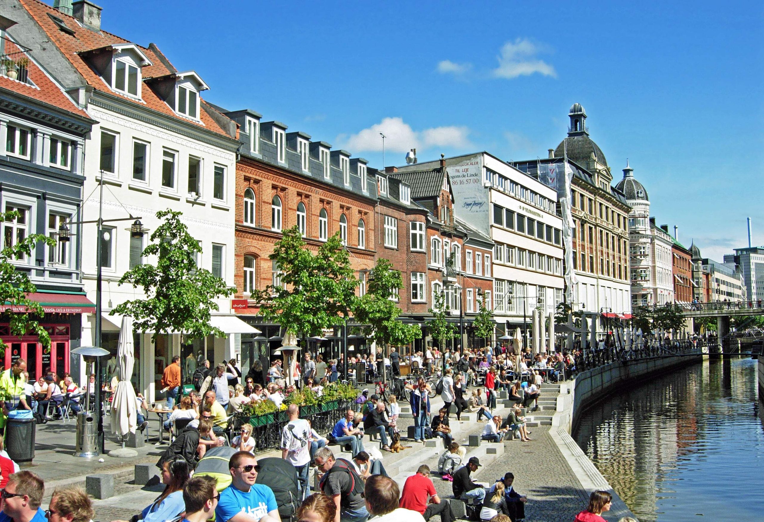 A crowded canal-side boulevard lined with European-style architecture.