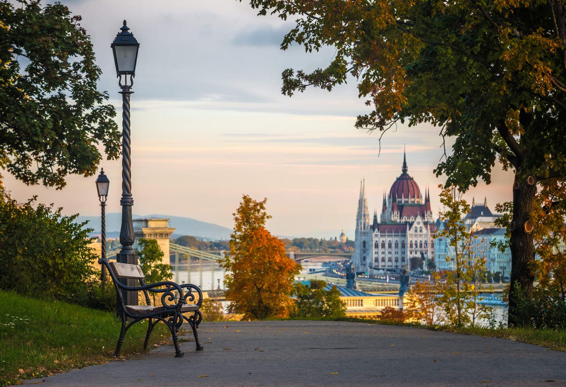 Budapest, Hungary - Bench and autumn foliage on the Buda hill with the Hungarian Parliament and Chain Bridge at background