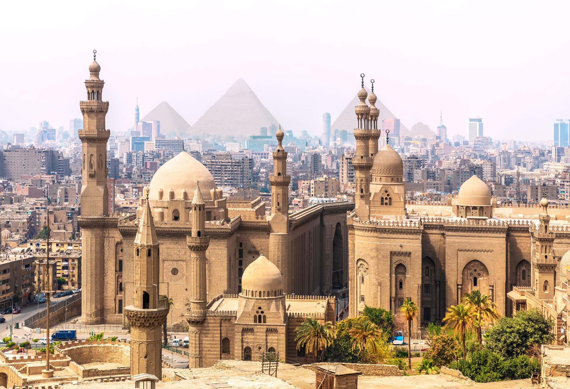 View of mosque in Cairo with Giza Pyramids in background, Egypt