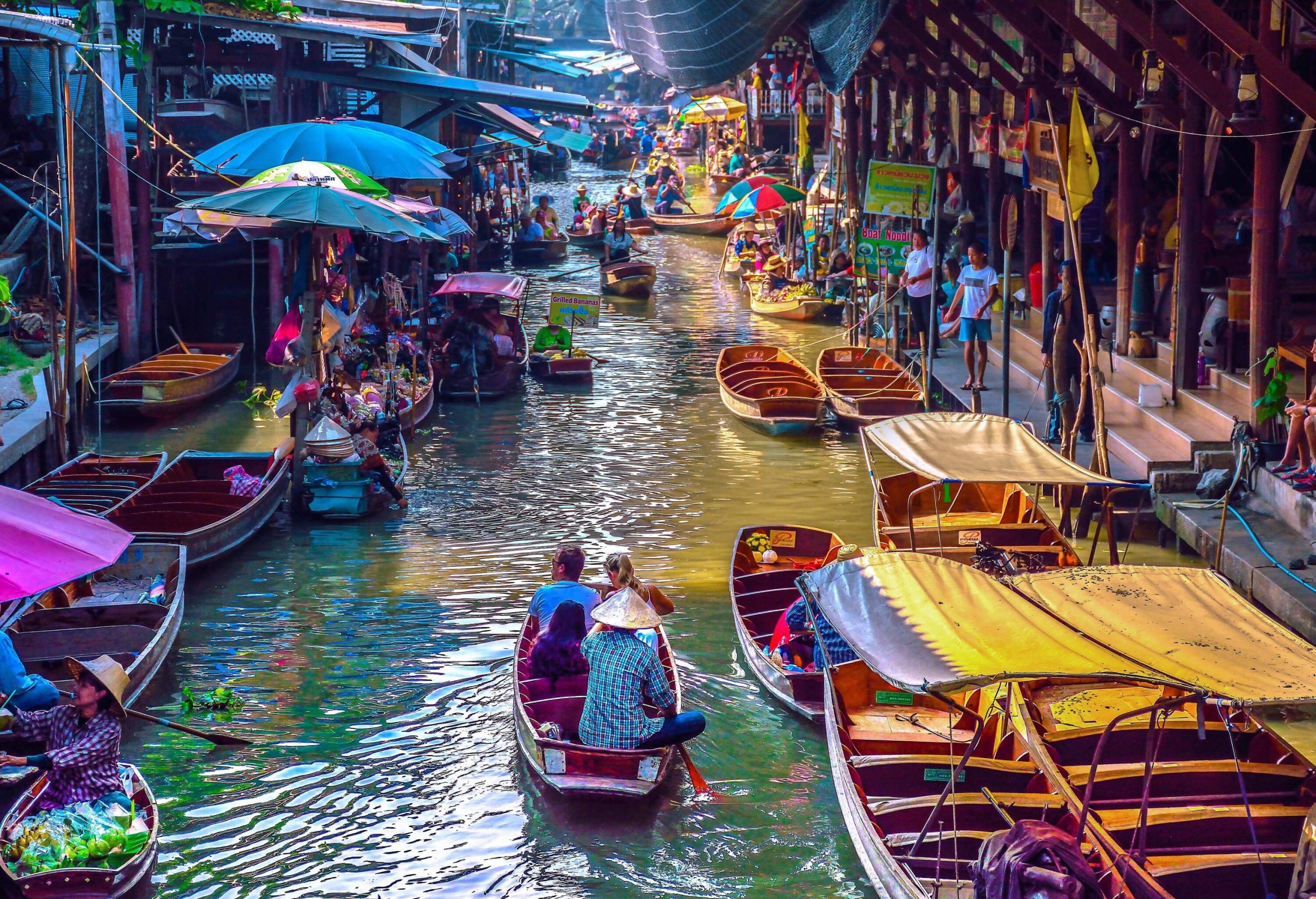 Vendors skillfully navigate their wooden boats through the bustling traditional floating market. 