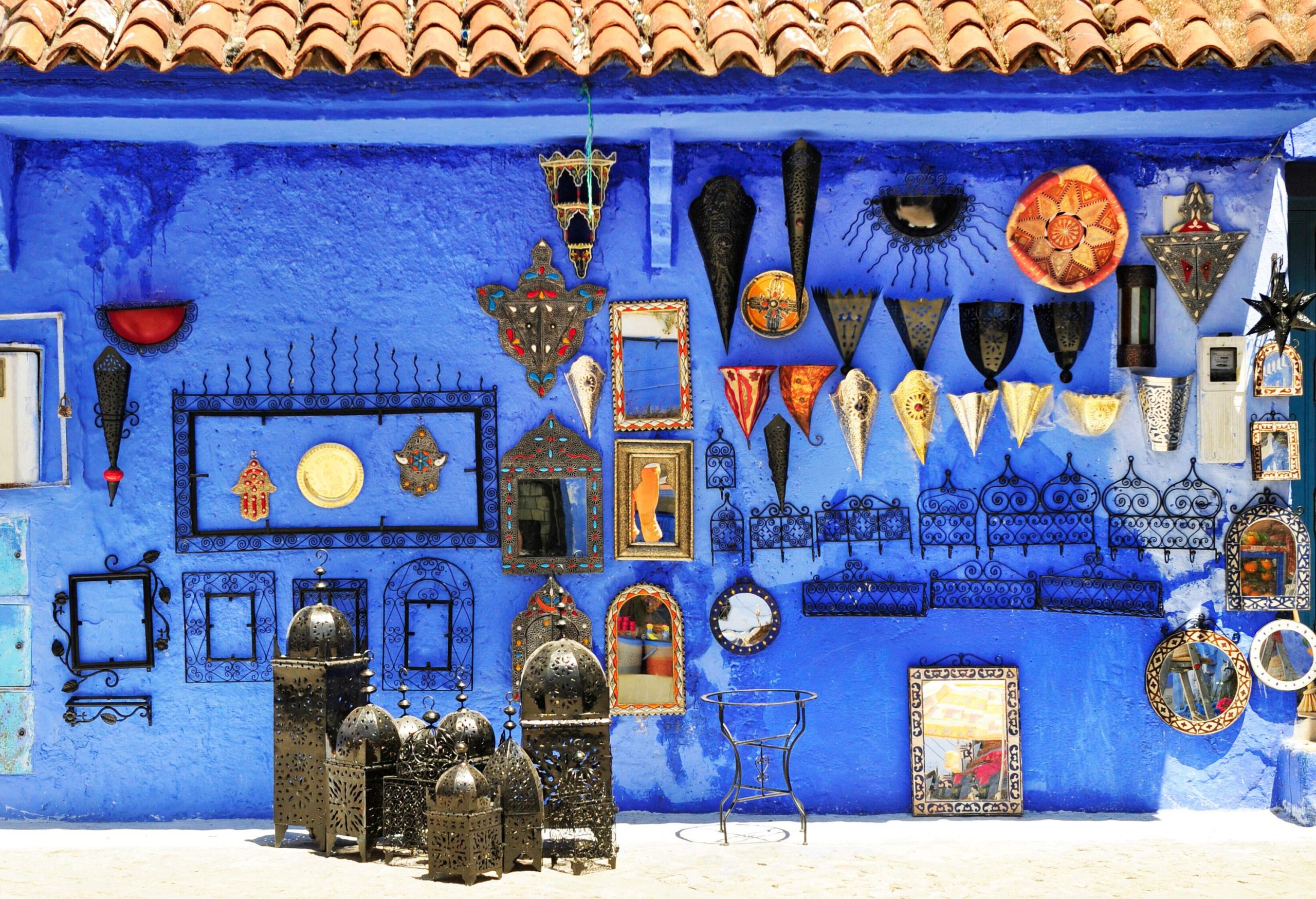 A blue stucco wall adorned with colourful ornaments in various shapes and sizes.