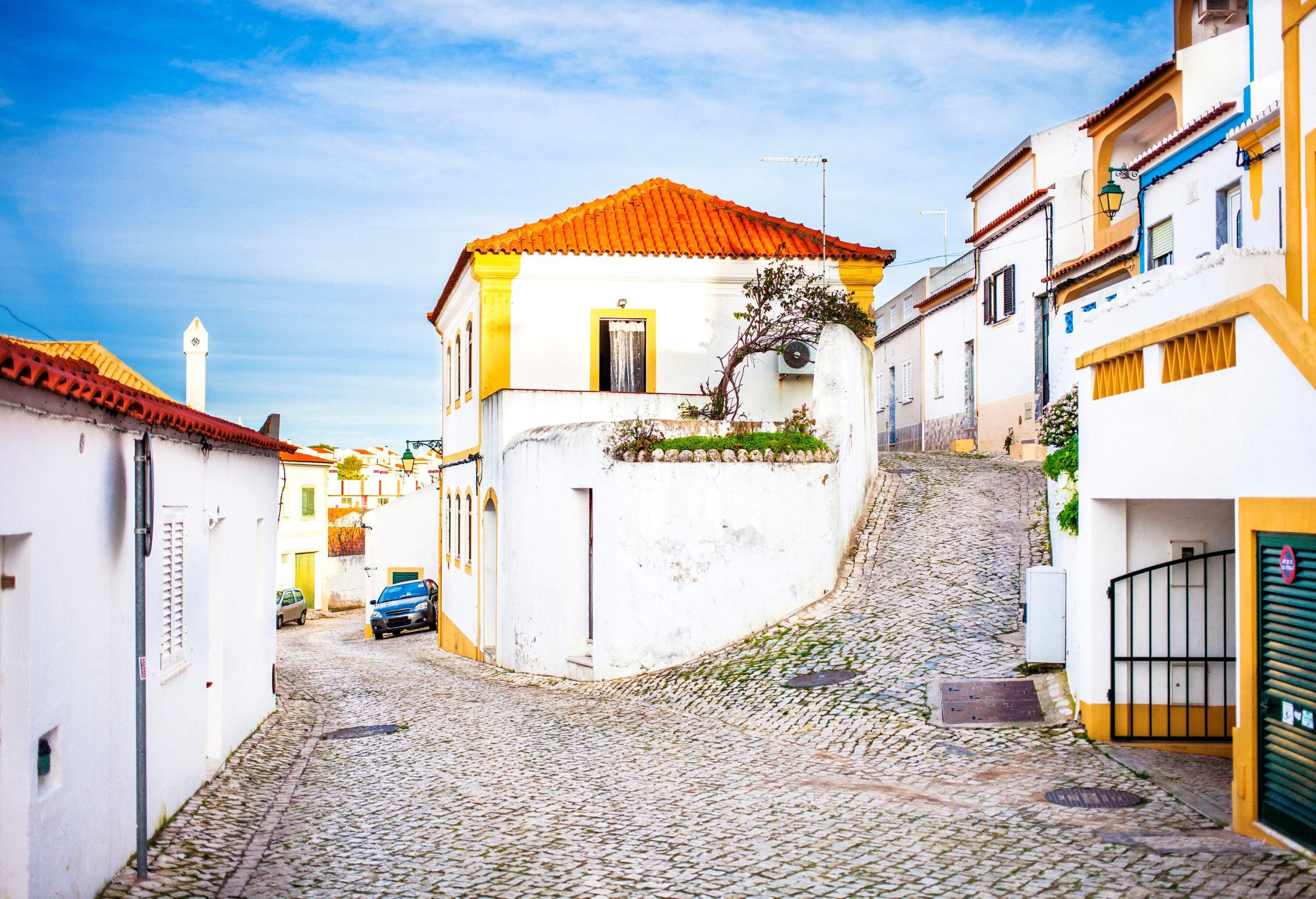 A village with narrow and steep cobblestone lanes surrounded by whitewashed houses.