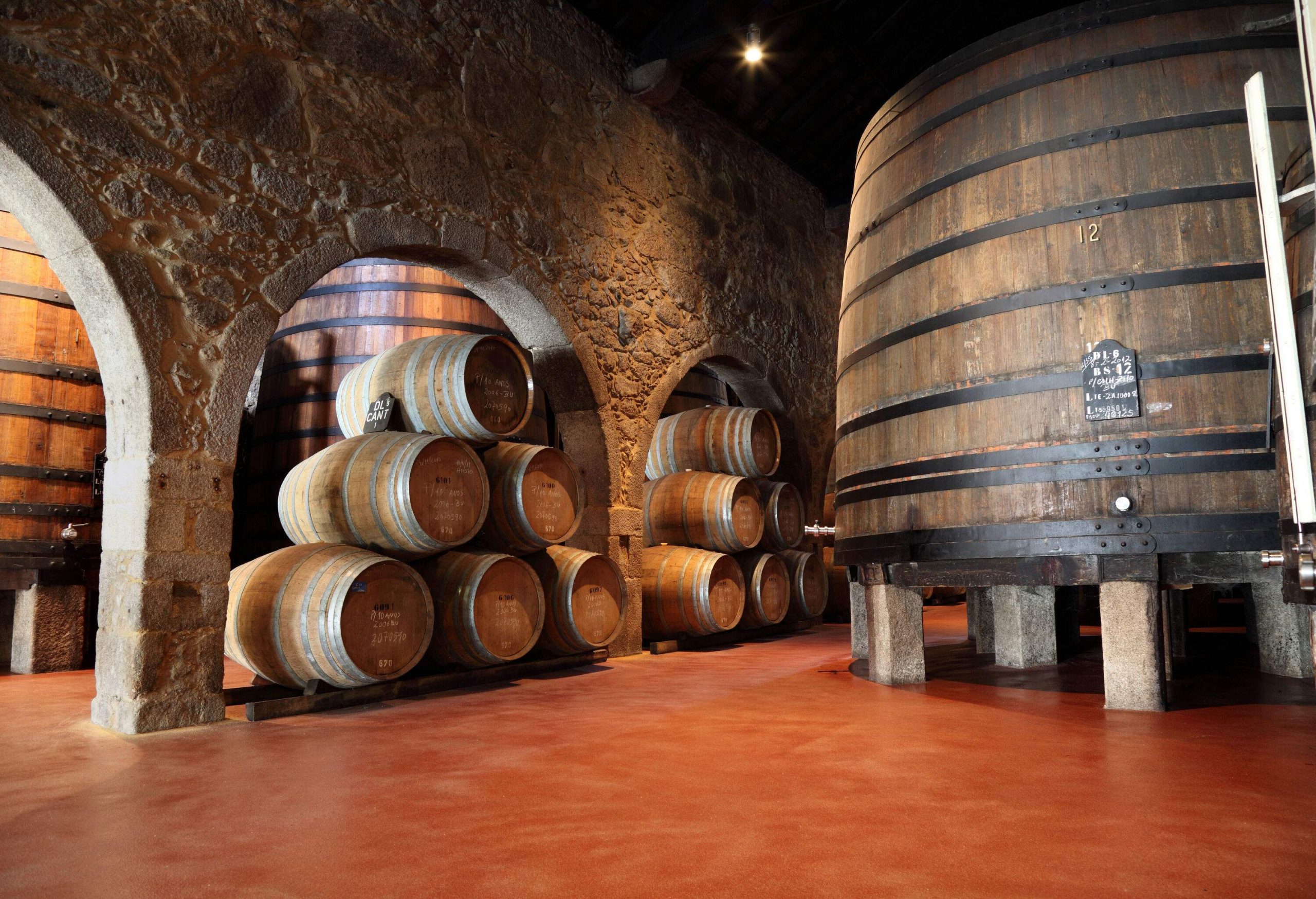 A stack of wooden barrels in a wine cellar.