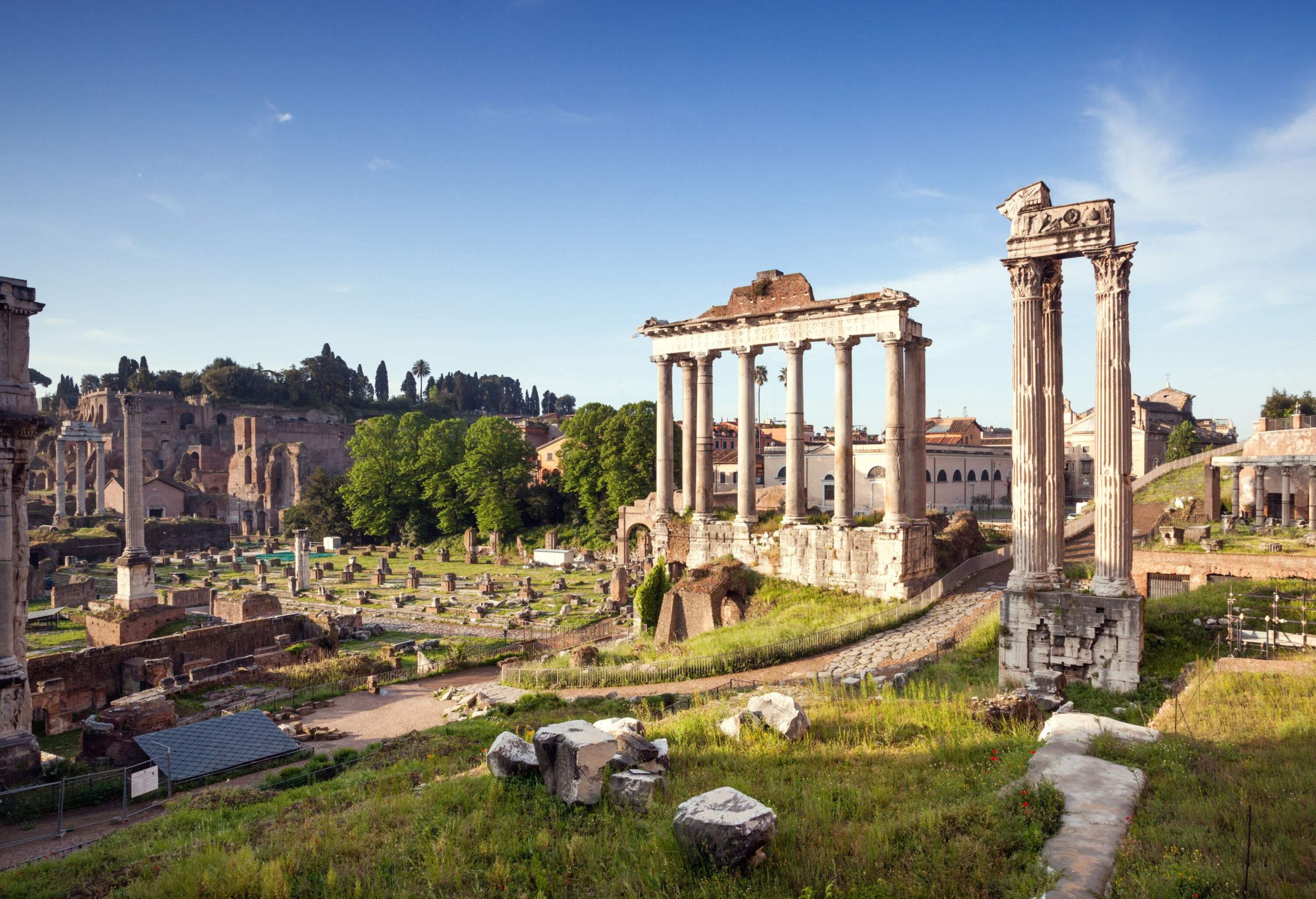 An archaeological site of a ruined temple with damaged columns and portico.