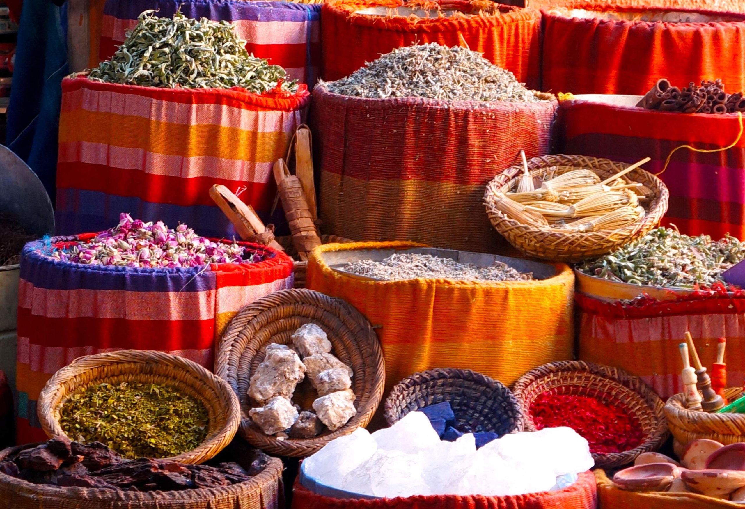 Stacks of colourful spices in colourful sacks.