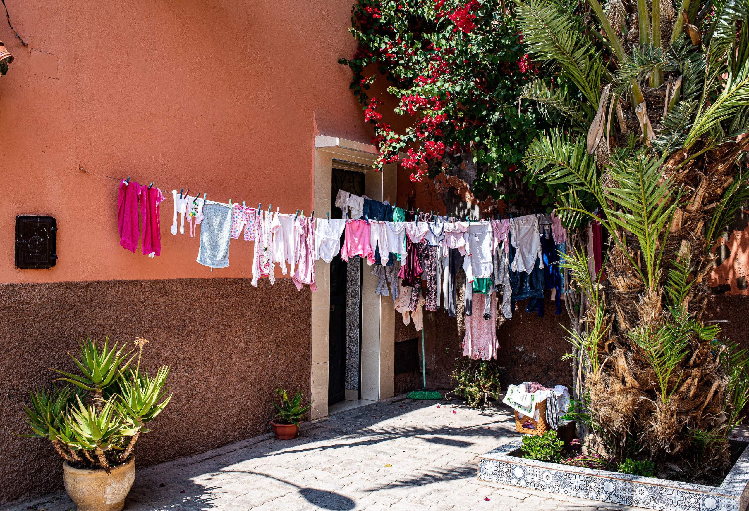 The front of a charming house is adorned with colourful laundry hanging to dry.