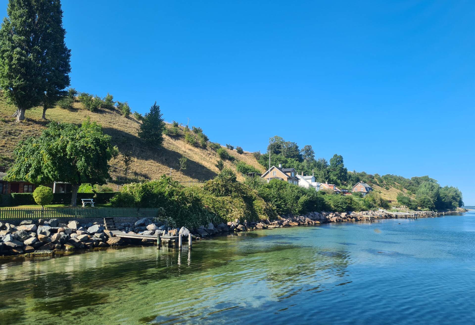 the swedish island Hven on a bright sunny day with houses and a bridge near the sea