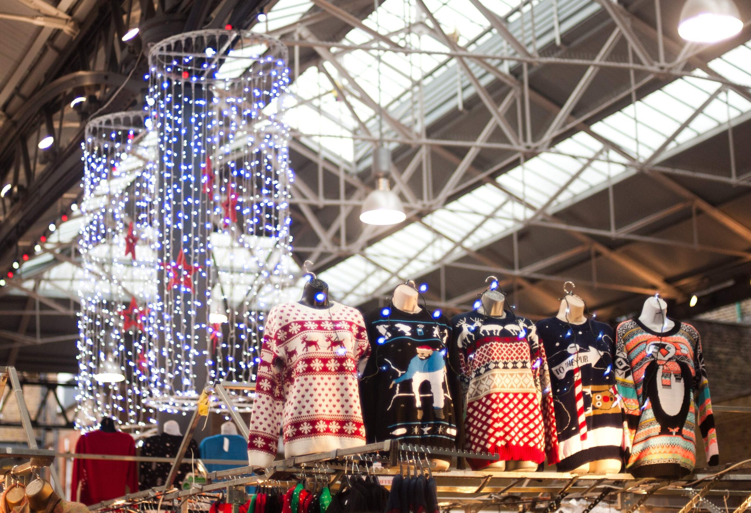 A Christmas market with many fairy lights, including a selection of Christmas jumpers