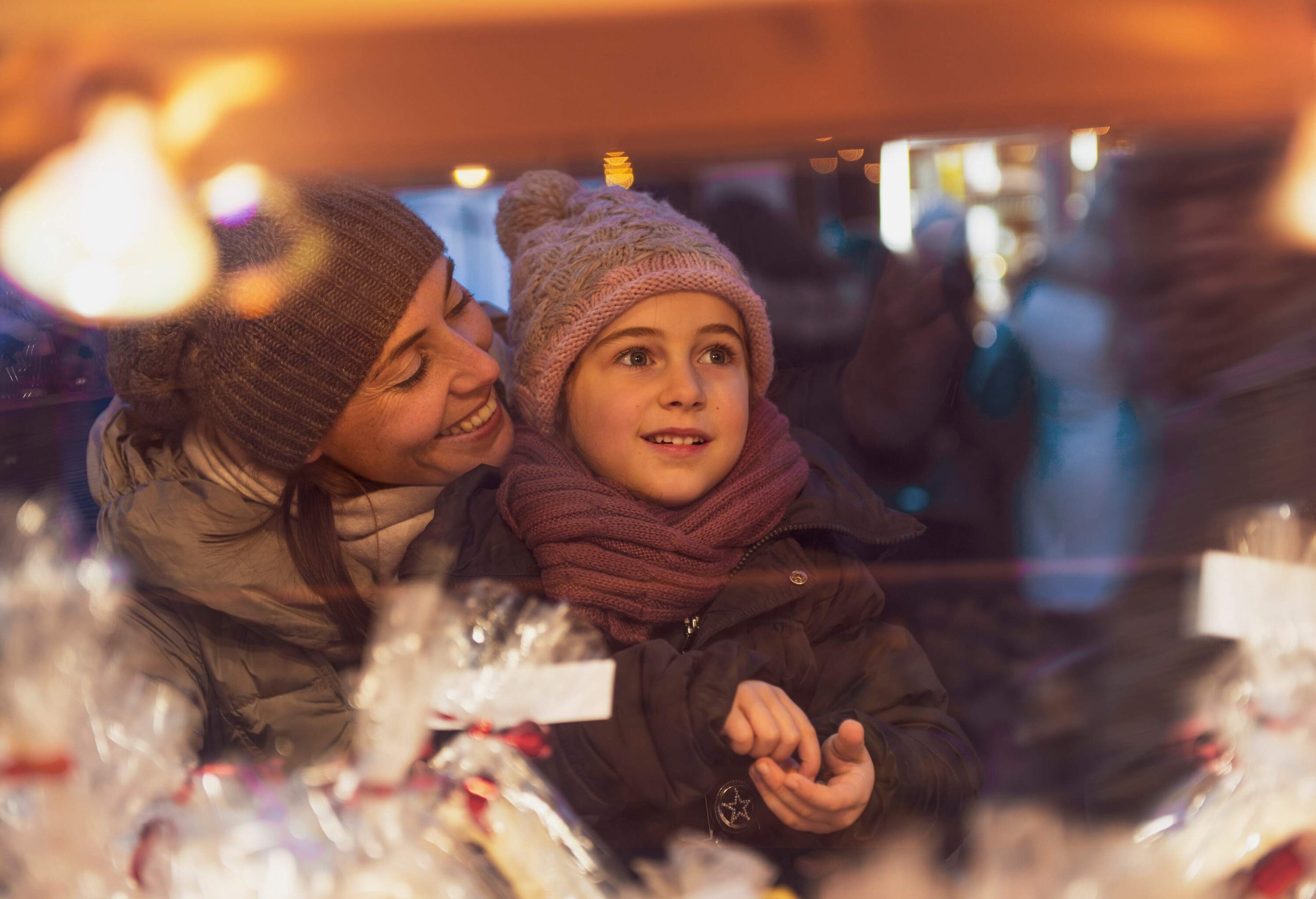 A child with her mother, in awe of the bright lights of the Christmas market.
