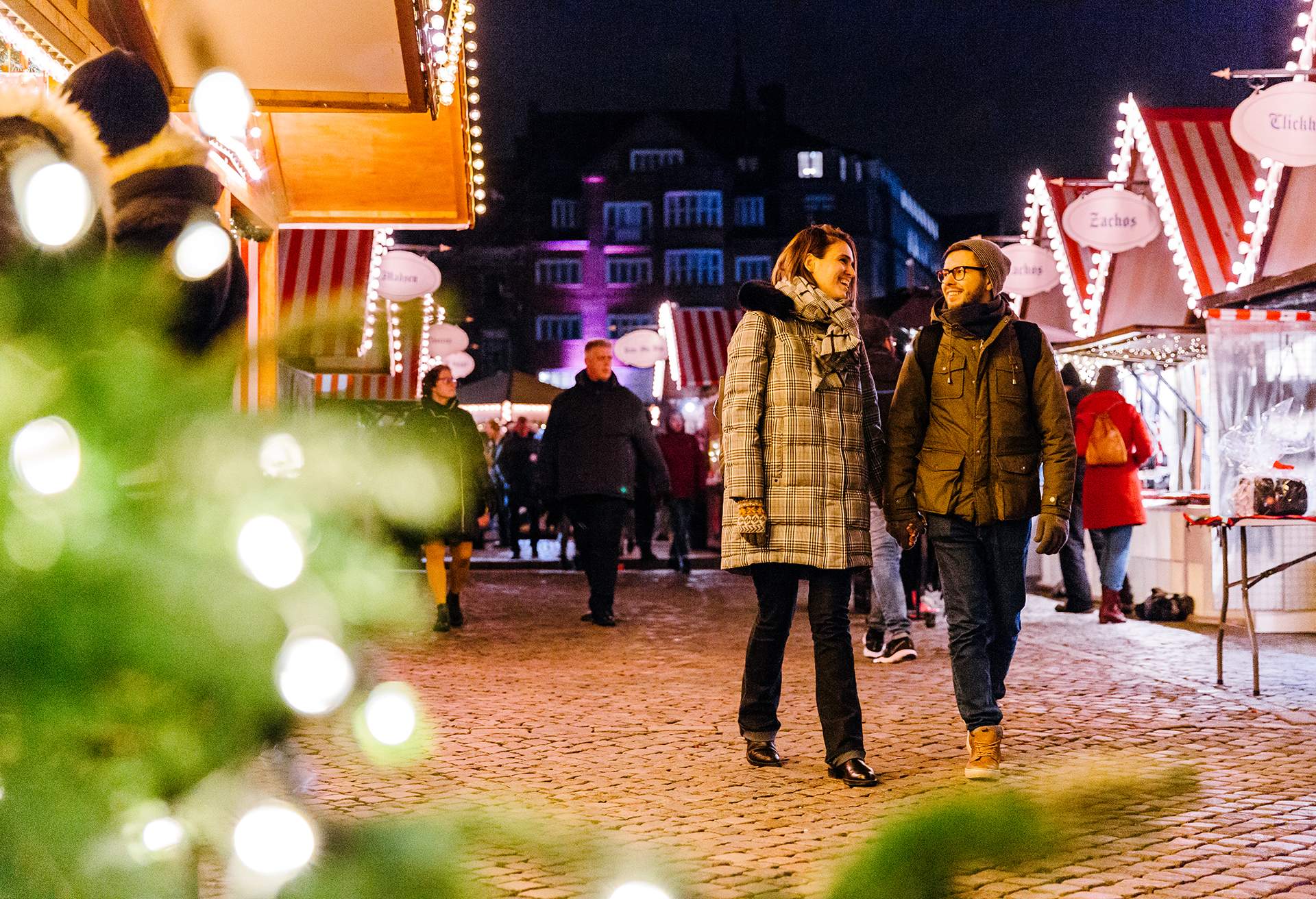 Couple walking along Christmas market in the evening, Copenhagen, Denmark