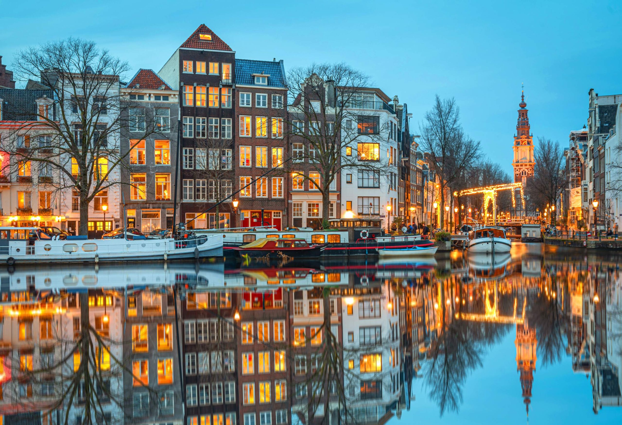 Amstel river at dusk. The city lights have just turned on giving a beautiful warm color to the beautiful buildings.