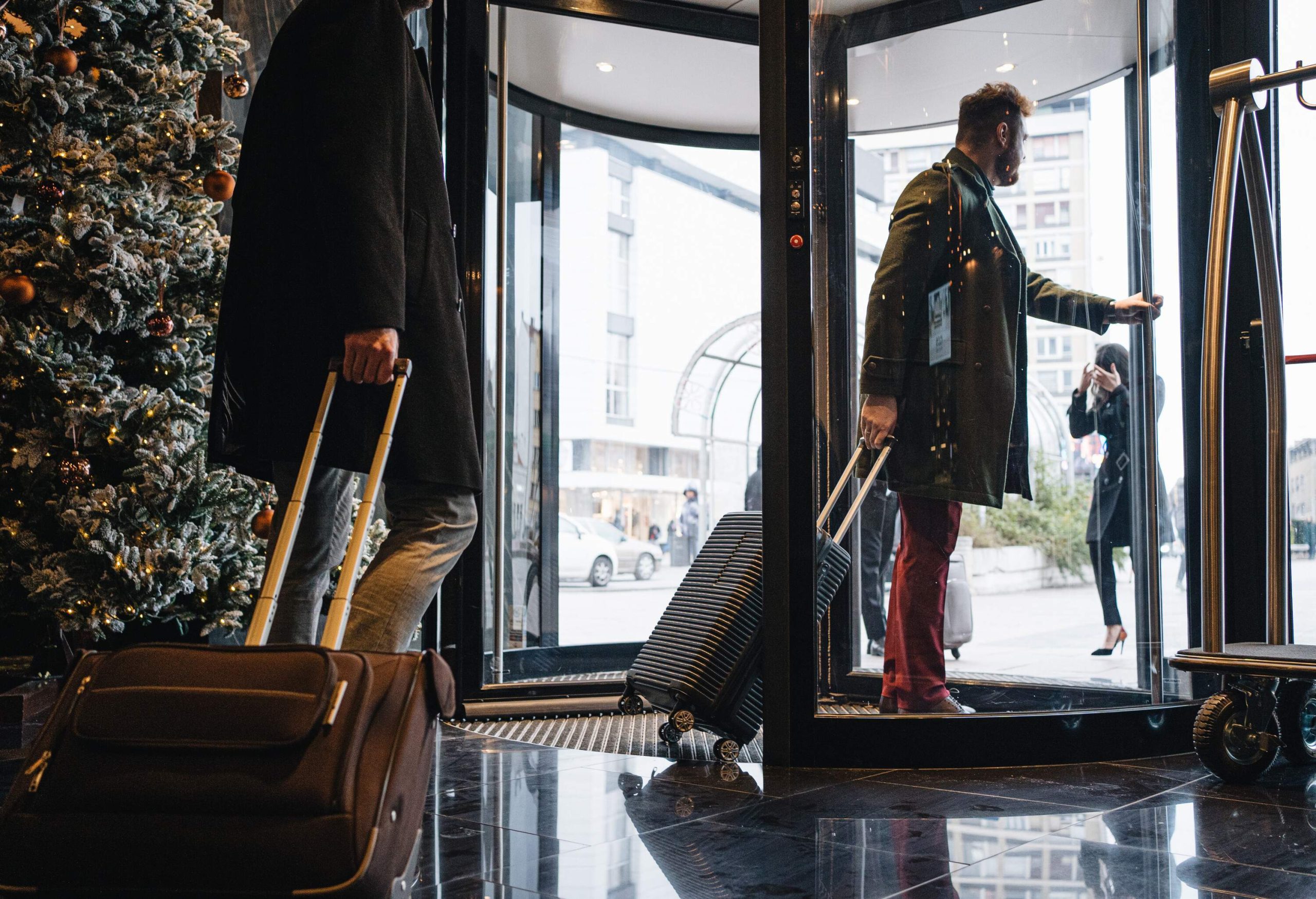 theme_travel_hotel_lobby_revolving_door_people_men_leaving_gettyimages-1243951592