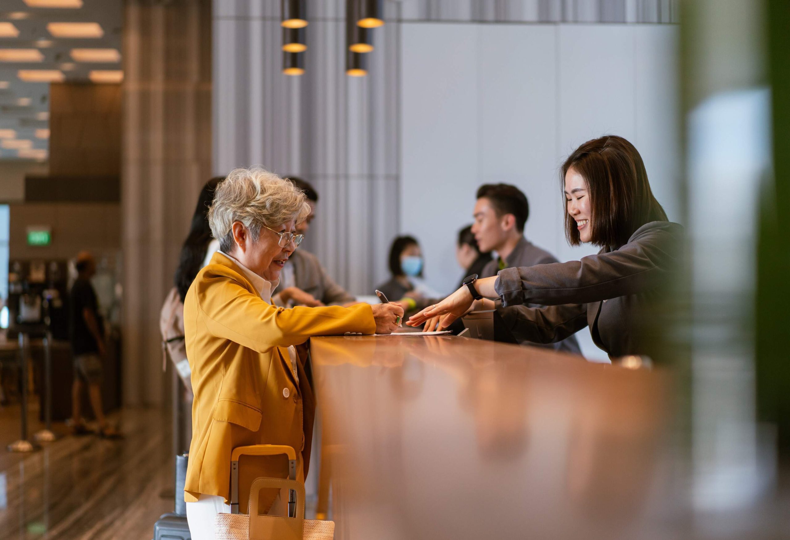 theme_travel_hotel_front_desk_people_receptionist_guest_gettyimages-1495601893