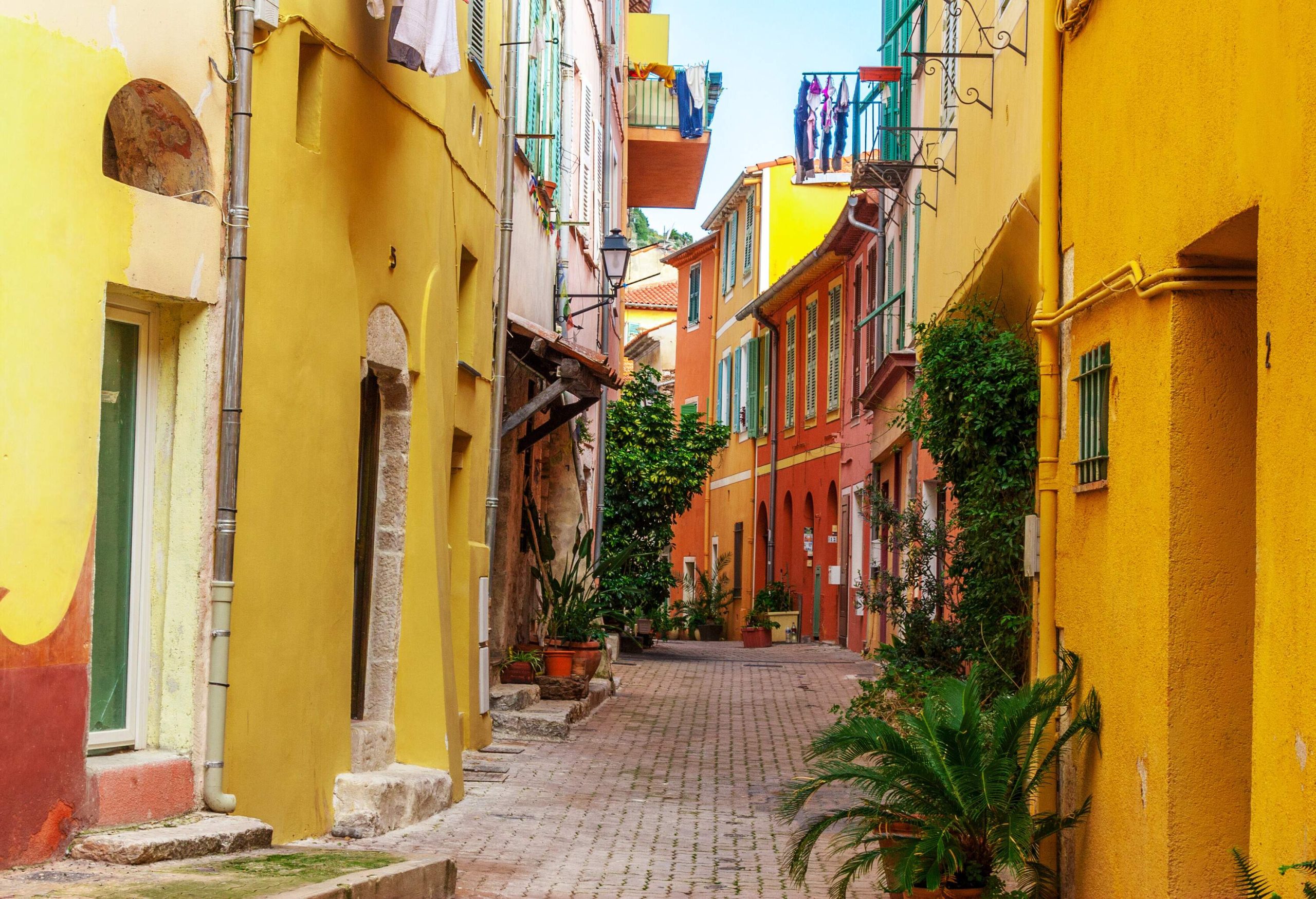 Houses painted in vibrant colours along a narrow paved lane.